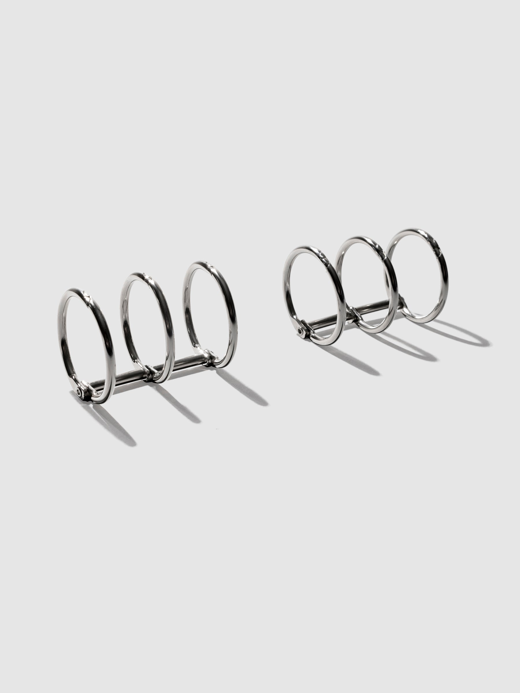 Silver rings displayed on a neutral background.