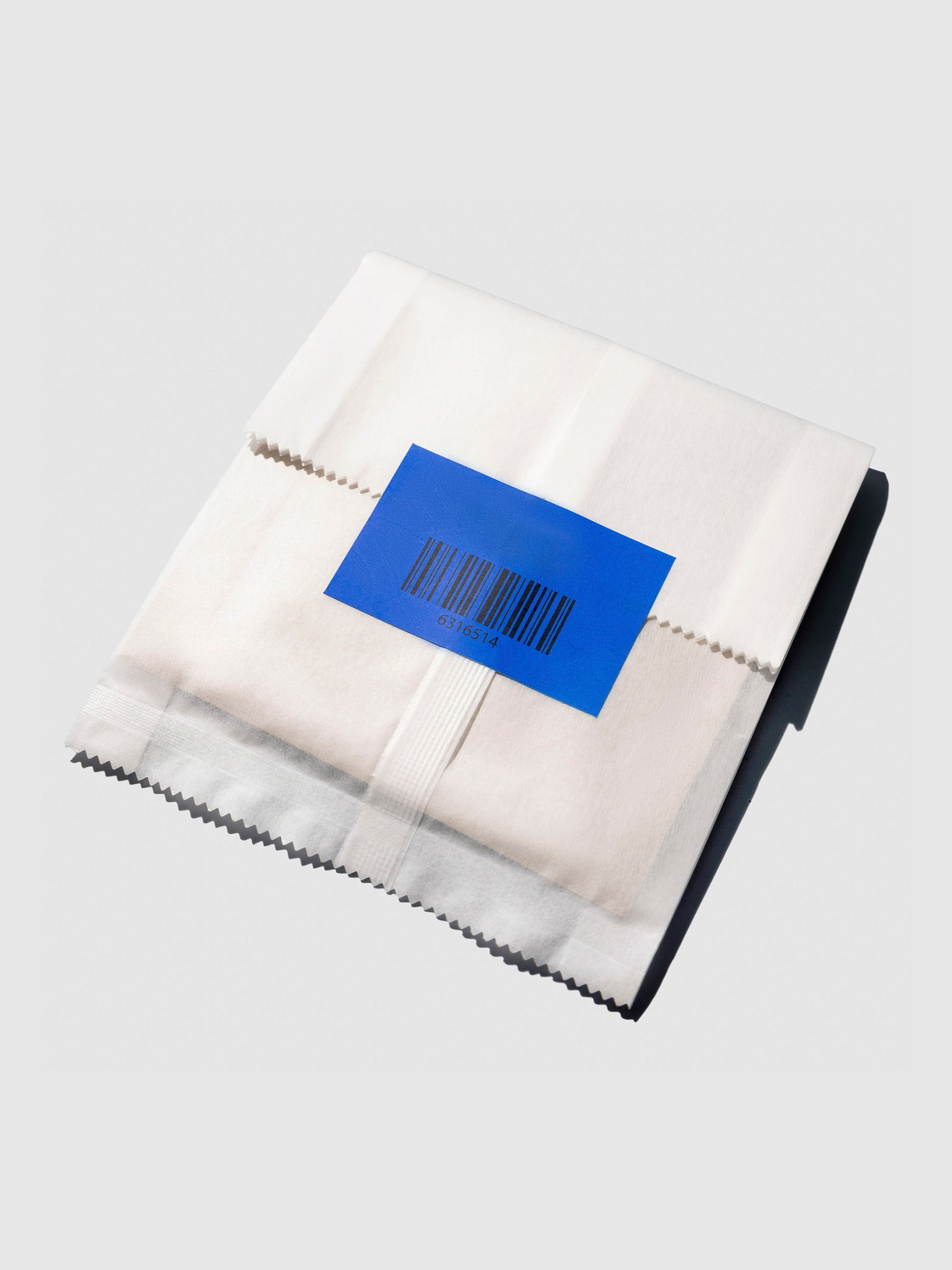 Closeup of product packaging, showing a bright blue sticker that keeps the packaging shut.