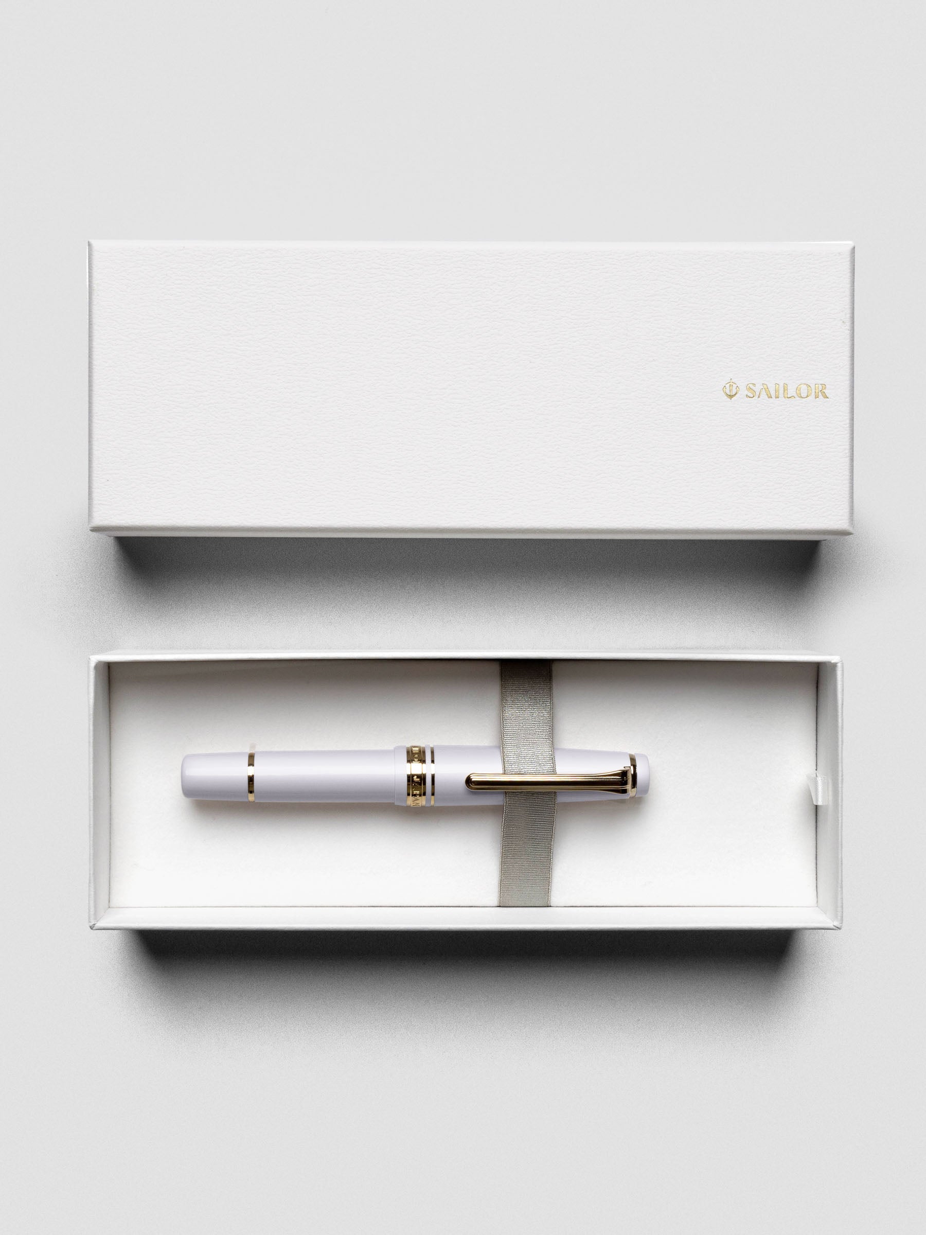 Flat lay of Sailor Pro Gear Slim Mini Fountain Pen in Ayur Gray with cap beside barrel.