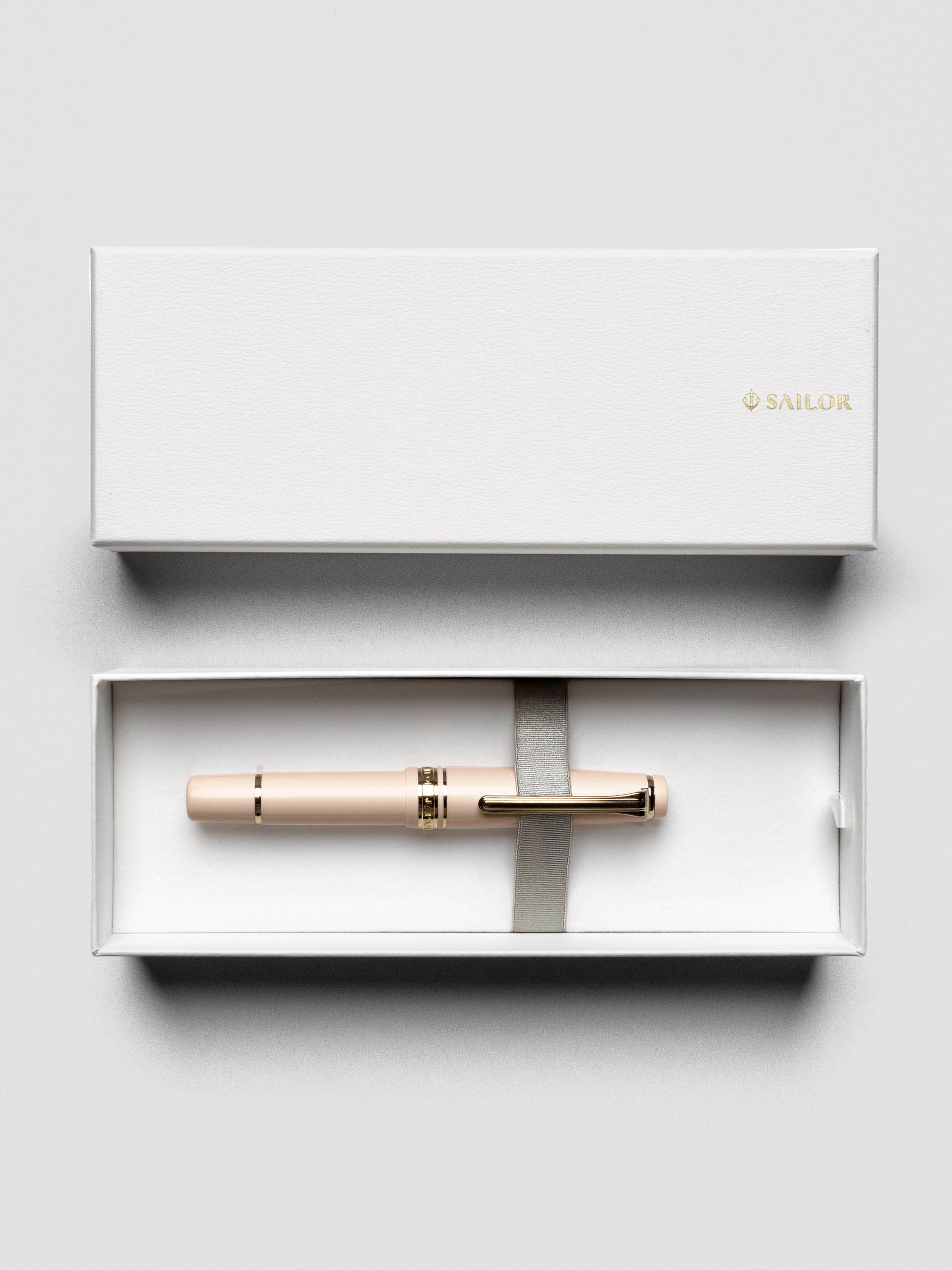 Overhead view of Sailor Pro Gear Slim Mini Fountain Pen in Zween Pink with cap beside barrel.