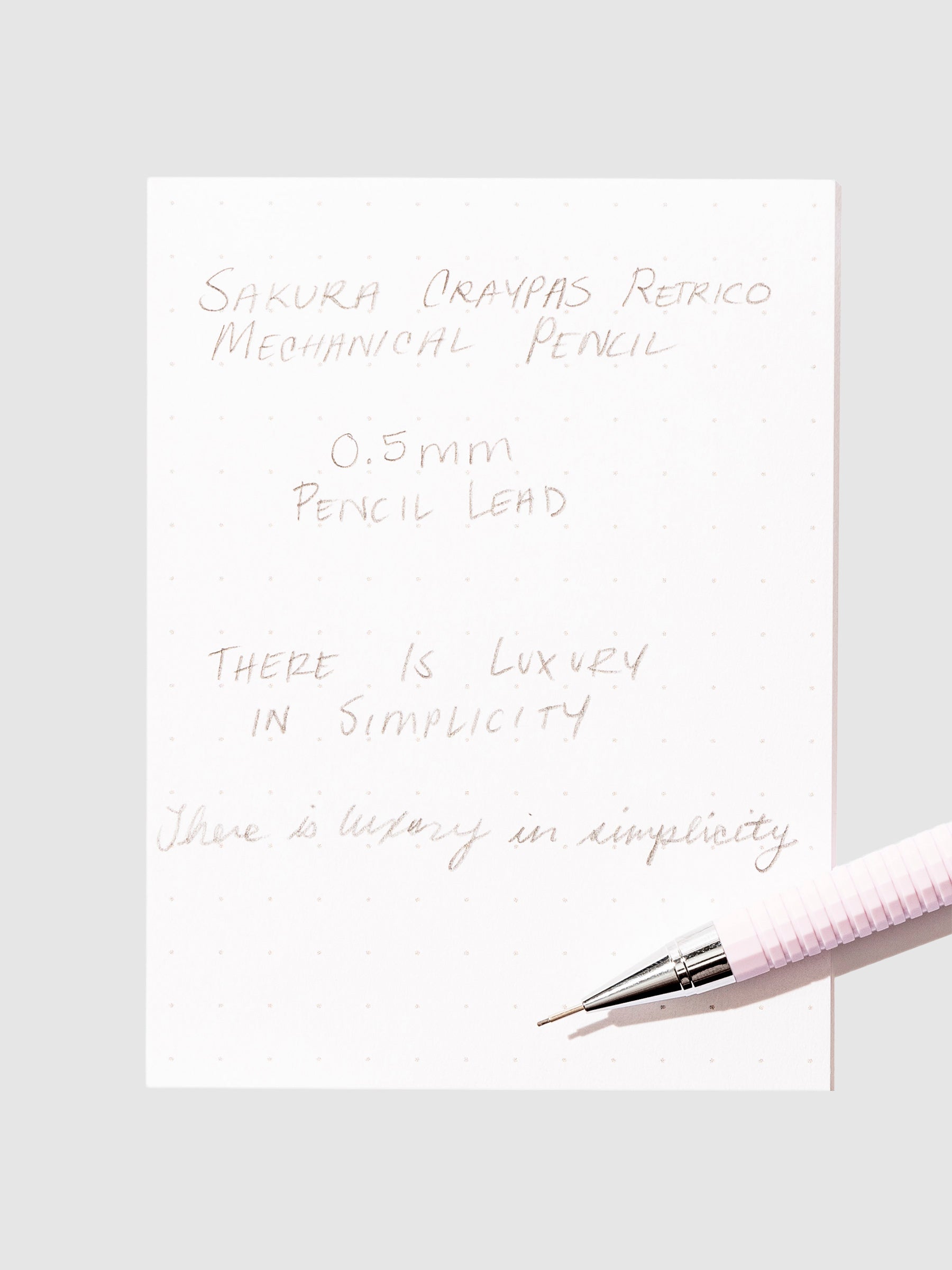 Writing sample with pencil displayed on a neutral background.