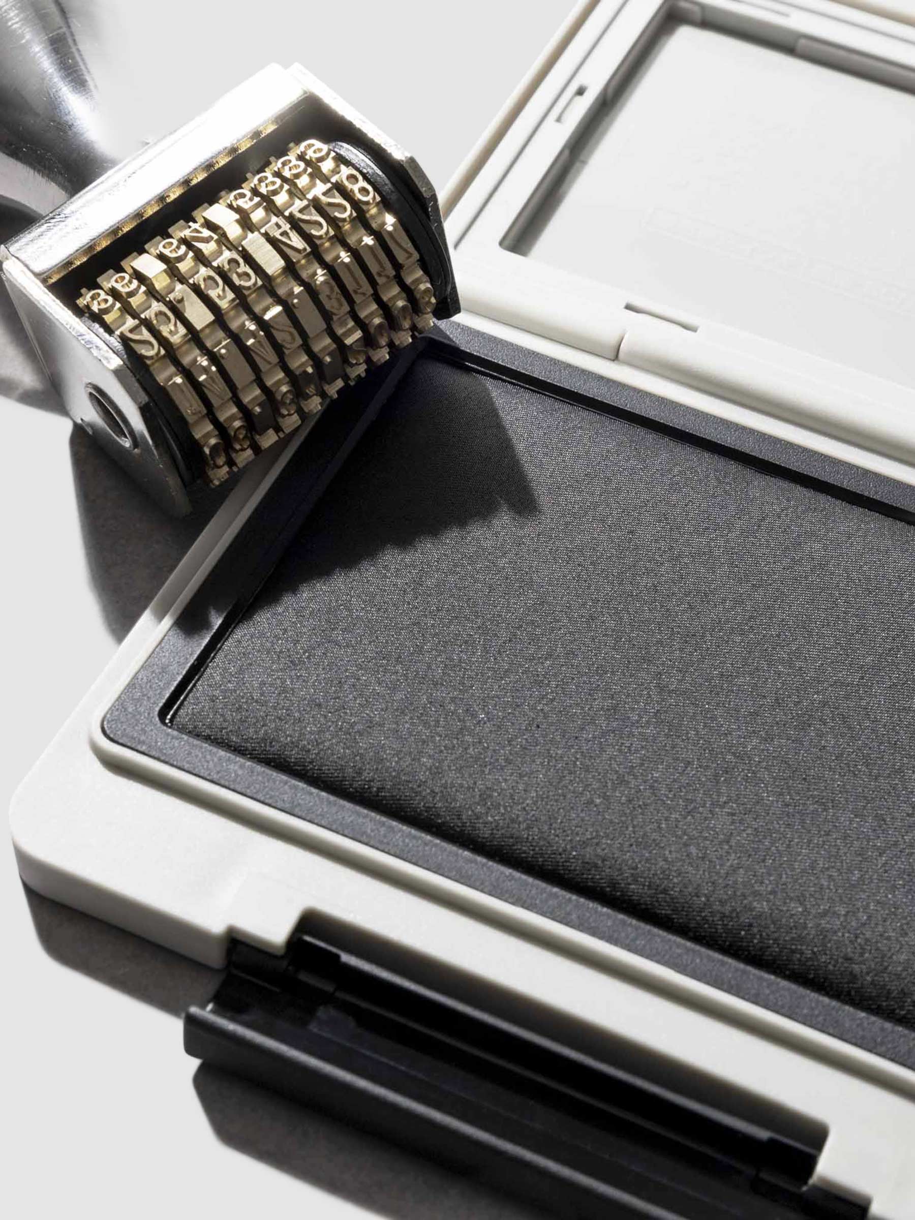 Stamp displayed open on a neutral background. A Cloth and Paper Date Stamp rests on the edge of the container.