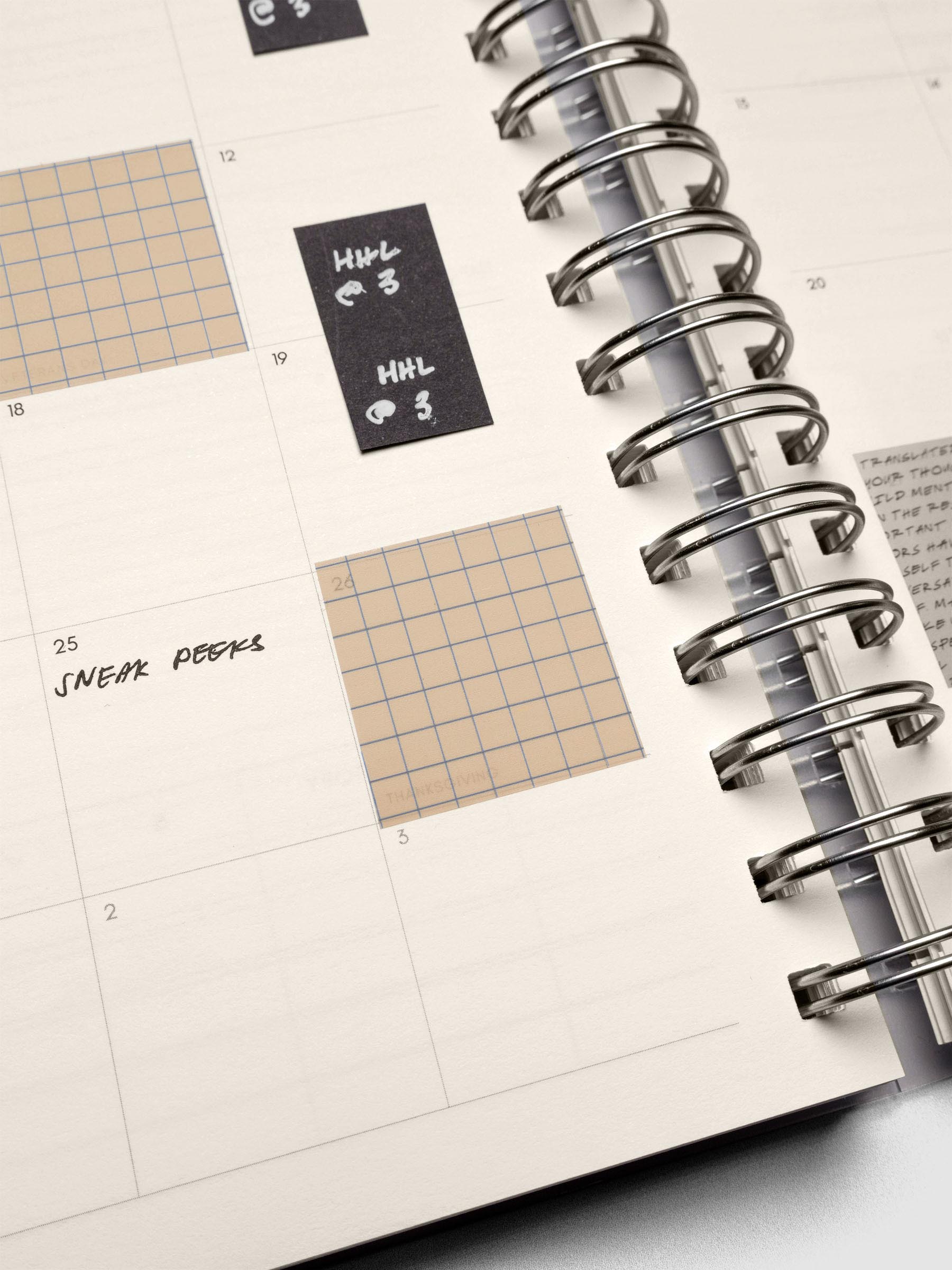 Close up of the Square Page Flags in the brown and blue, semi-transparent graph pattern in a spiral planner.