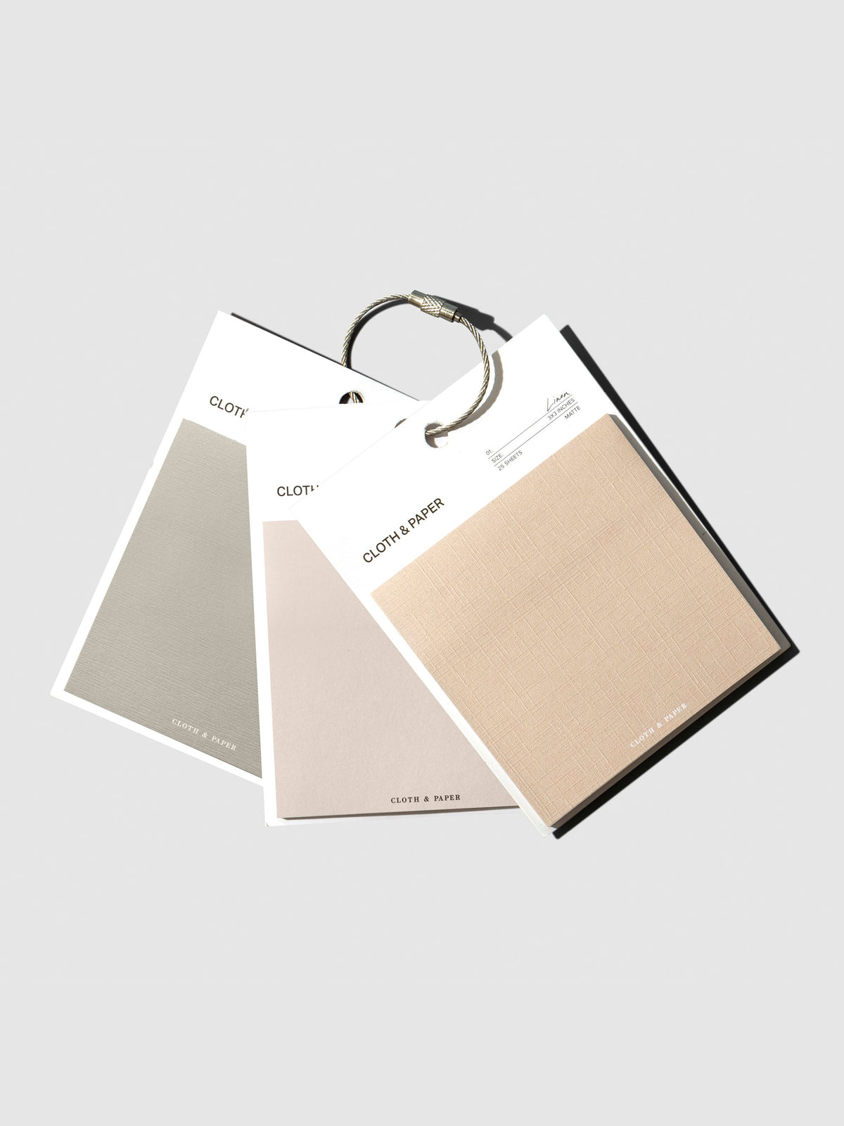 Sticky Note Swatches, Cloth and Paper. Earl Grey, Ibiza, and Angora sticky notes clipped together with a metal ring on a neutral background.