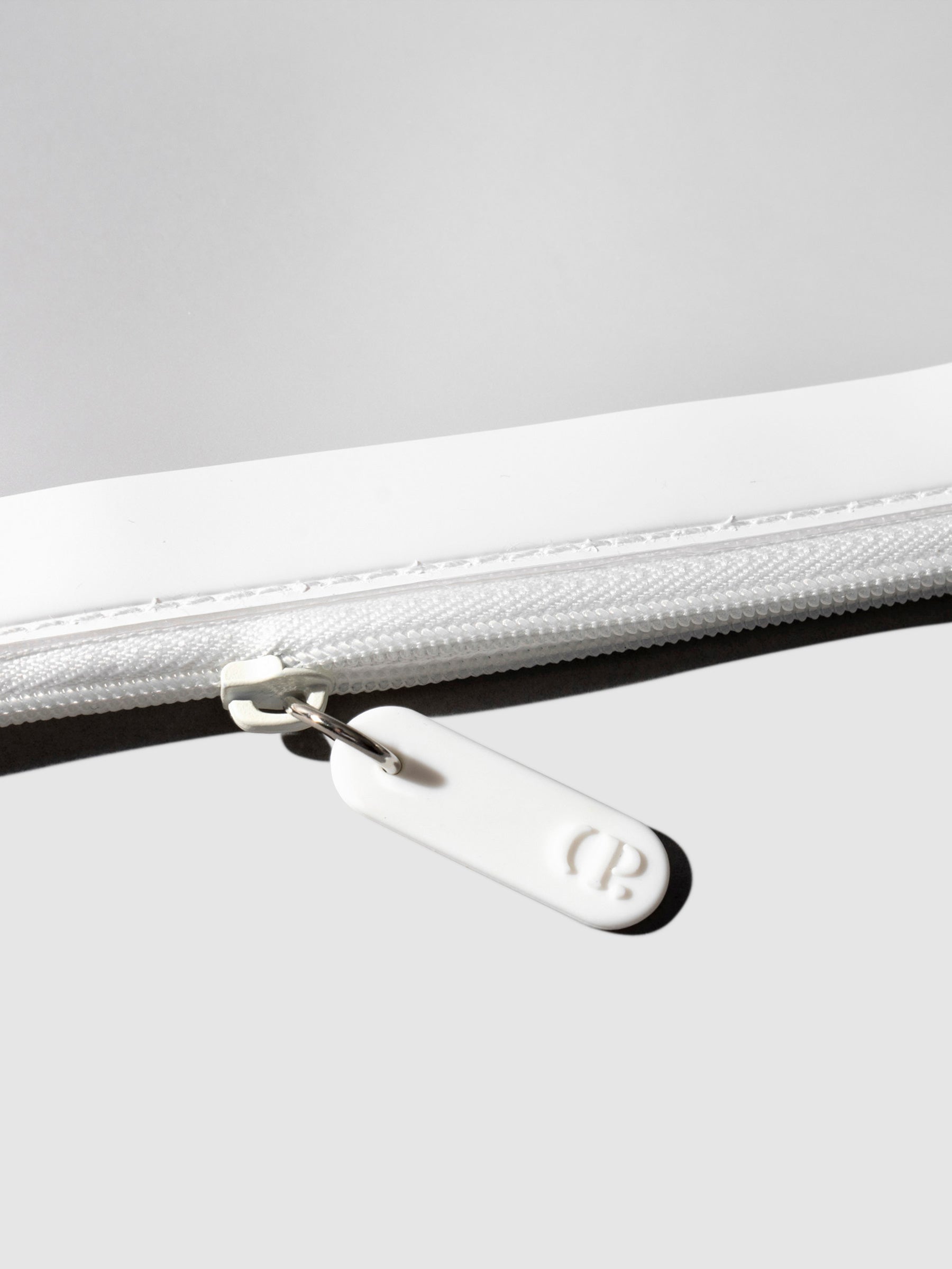 Closeup of white zipper detailing on bag.