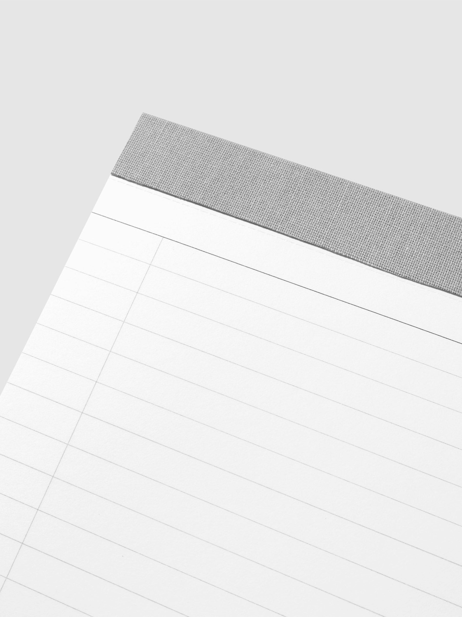 Closeup of notepad's task checklist layout and gray fabric spine.