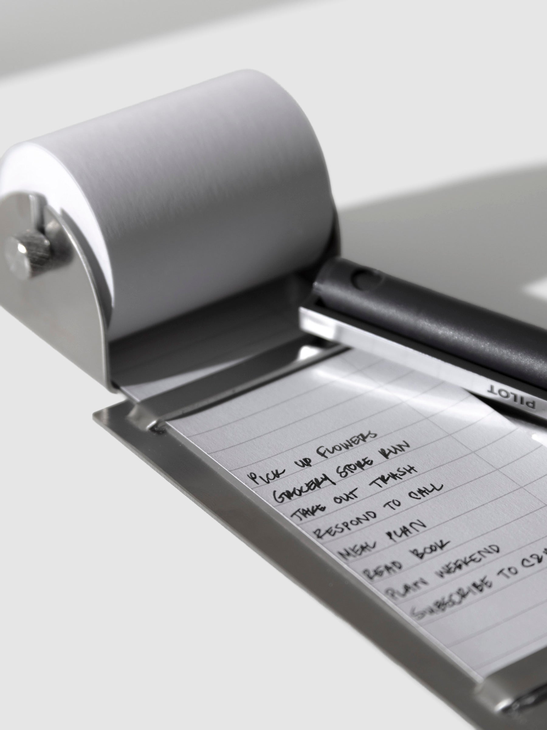 Task roller shown on a neutral background. A pen is shown resting on it, having filled out a task list.