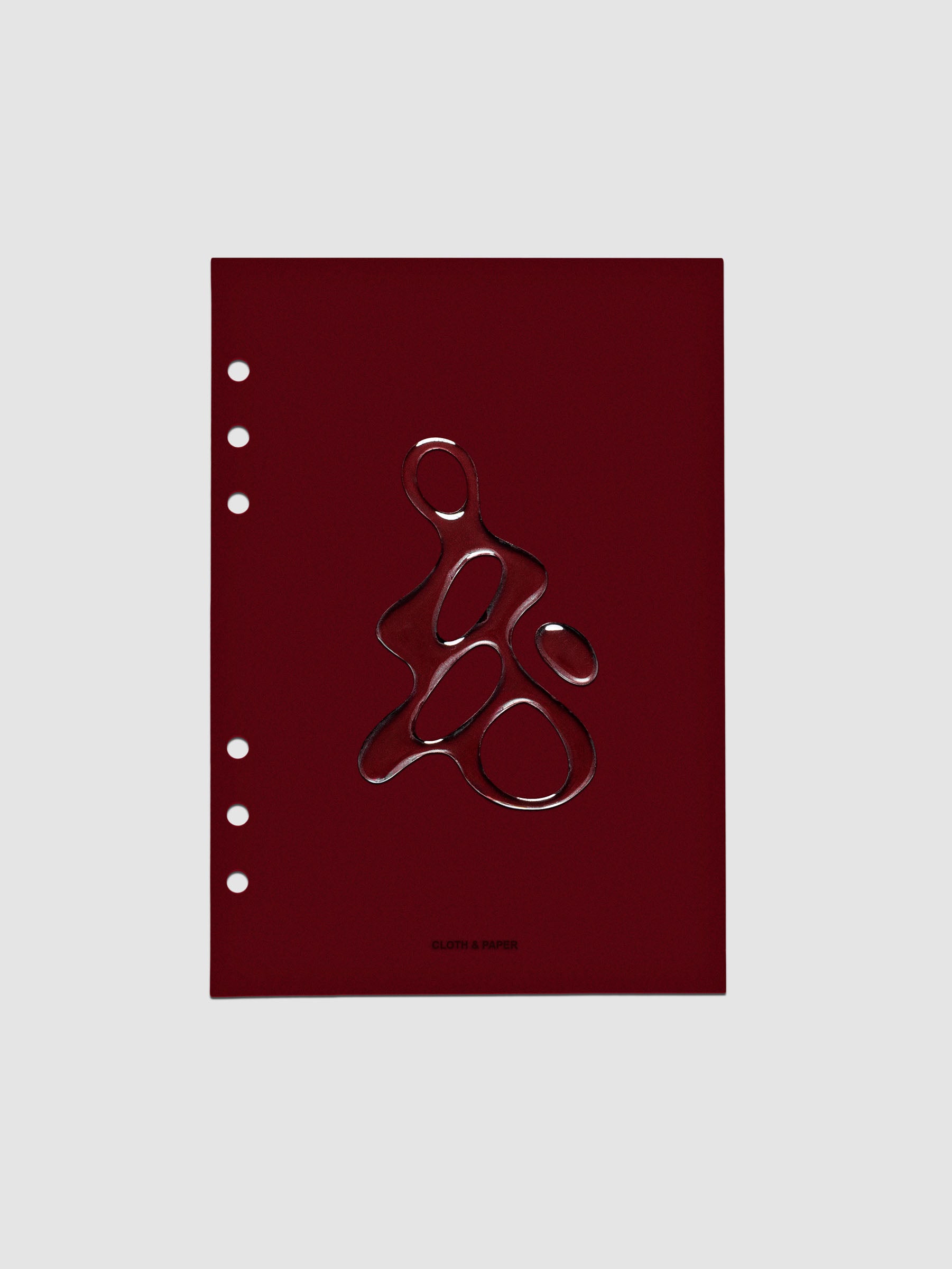 Dark red, semi-transparent, and glossy plastic planner dashboard with organic raised shape design in size A5 on a neutral background.