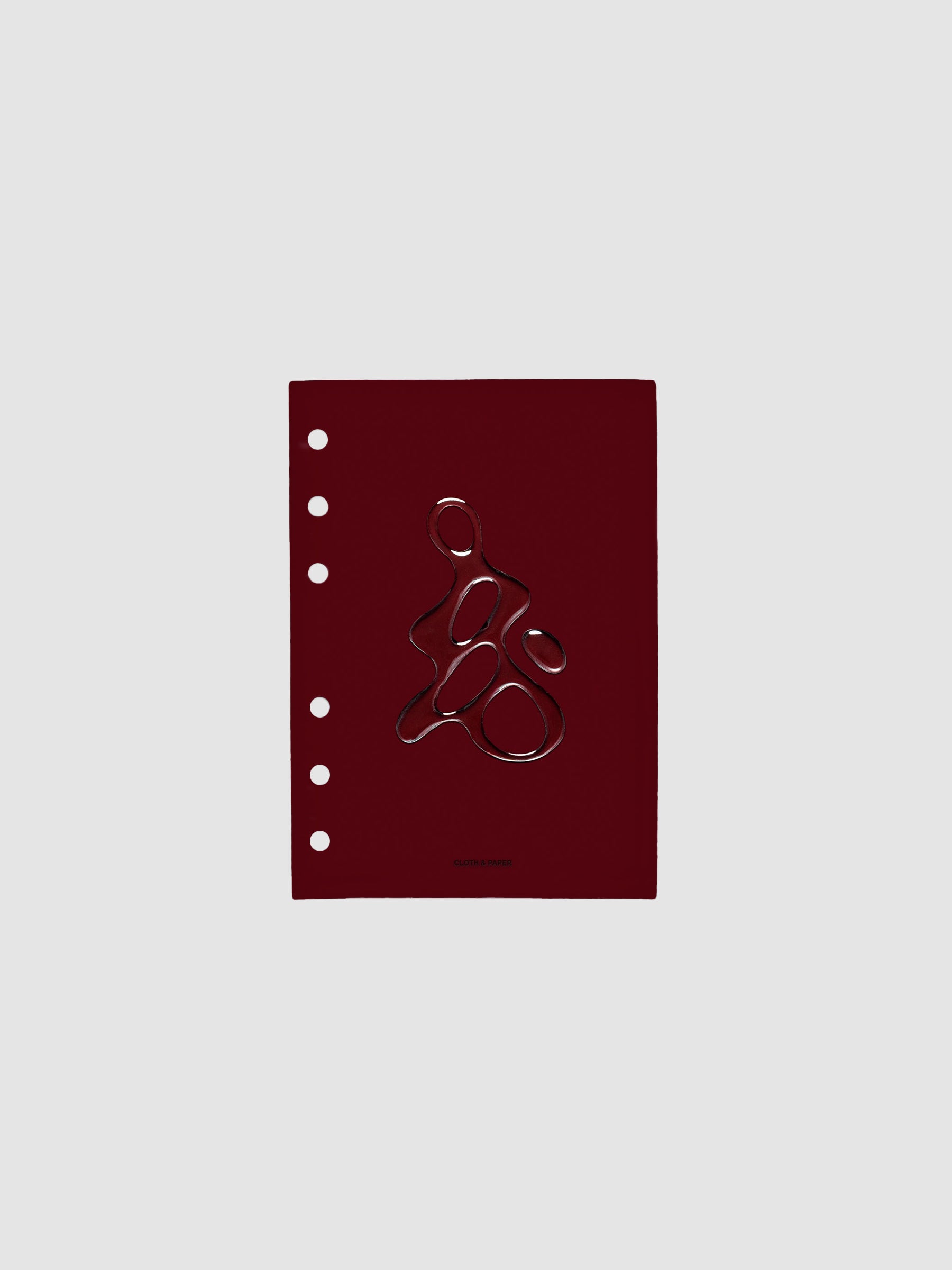 Dark red, semi-transparent, and glossy plastic planner dashboard with organic raised shape design in size A6 on a neutral background.