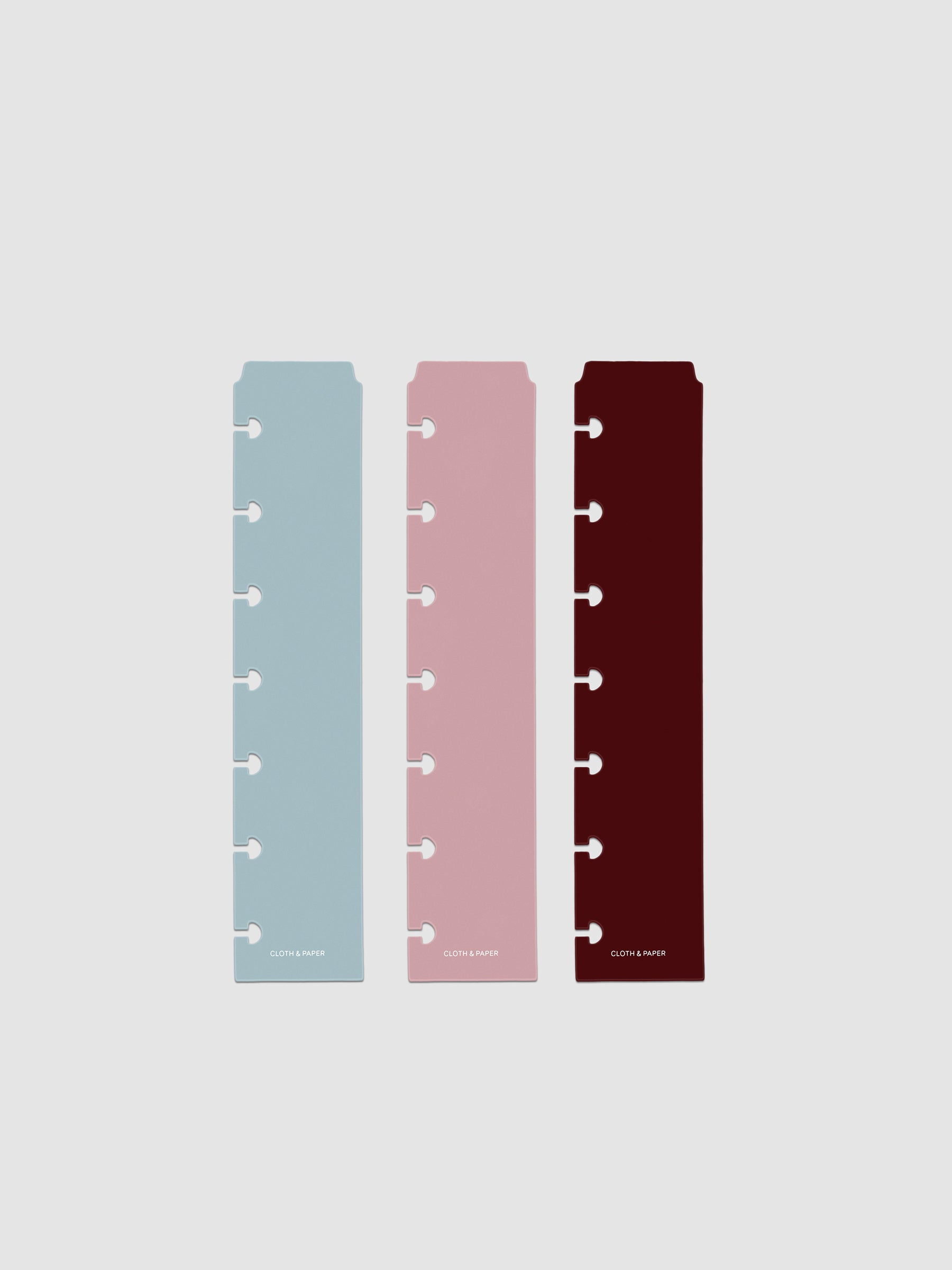 Set of three narrow page markers pre-punched for HP Mini planners in light blue, pink, and burgundy on a neutral background.
