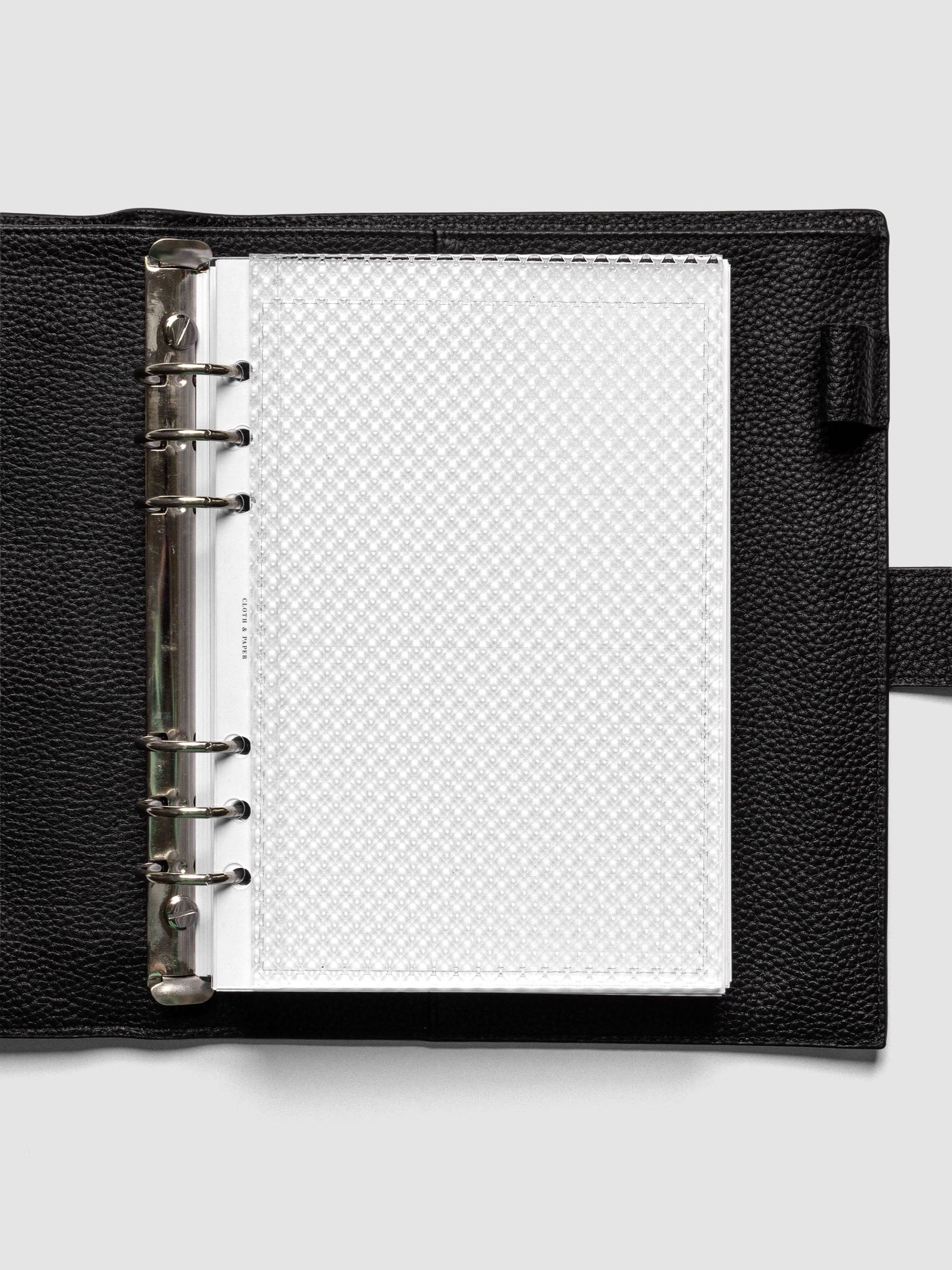 Clear, textured Studded Planner Dashboard in the size A5, shown ringbound in a black leather agenda.