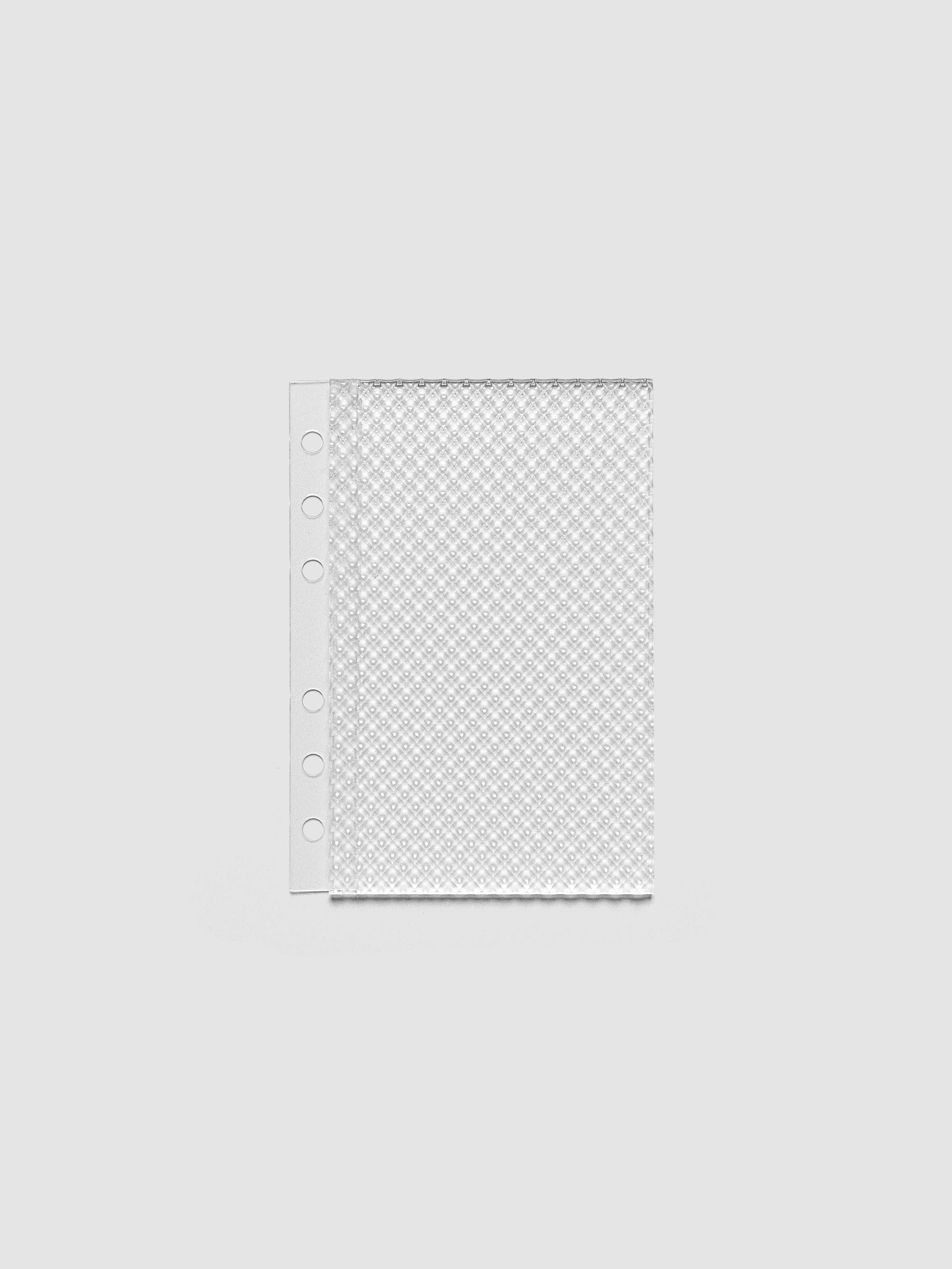 Clear, textured Studded Planner Dashboard in the size A6, on a neutral background.