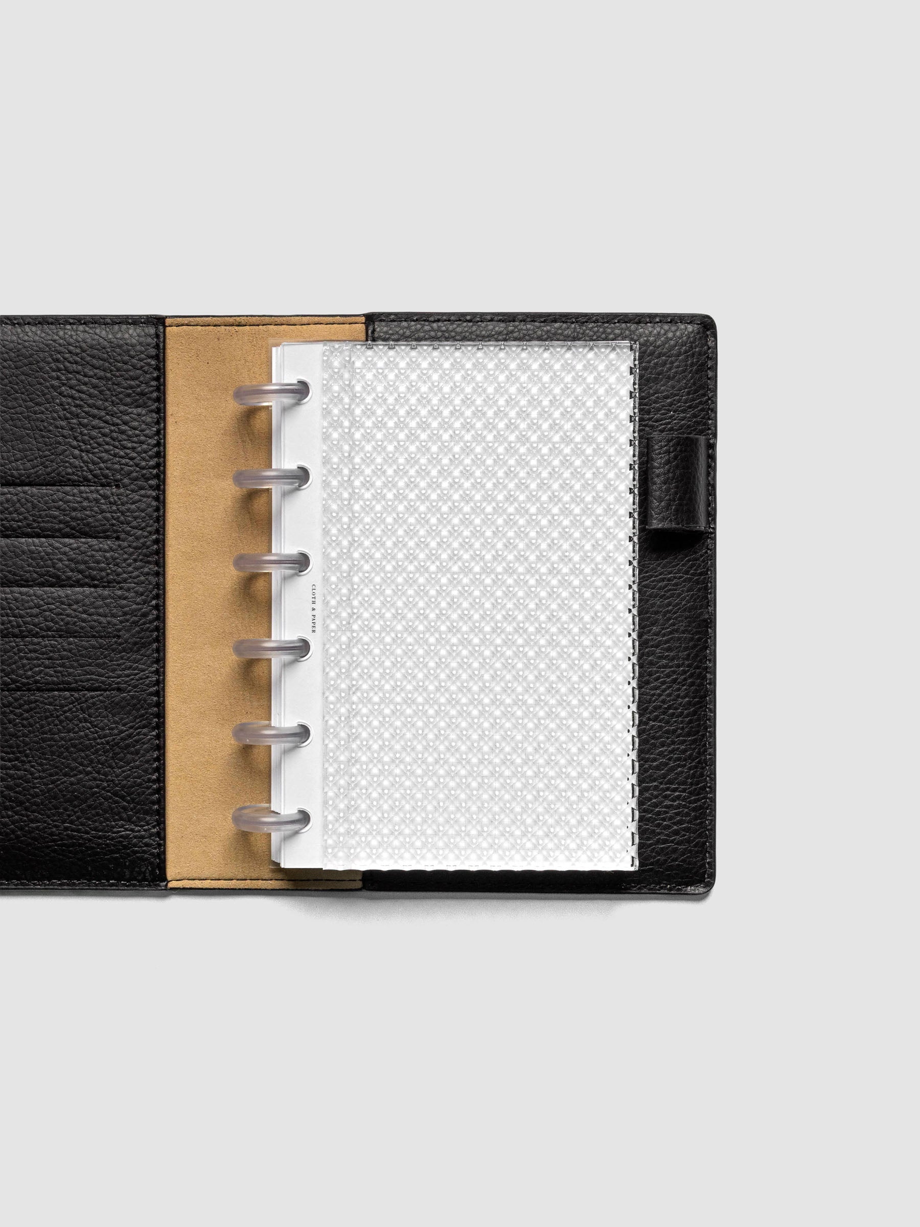 Clear, textured Studded Planner Dashboard in the size CP Petite, shown discbound in a black leather folio.
