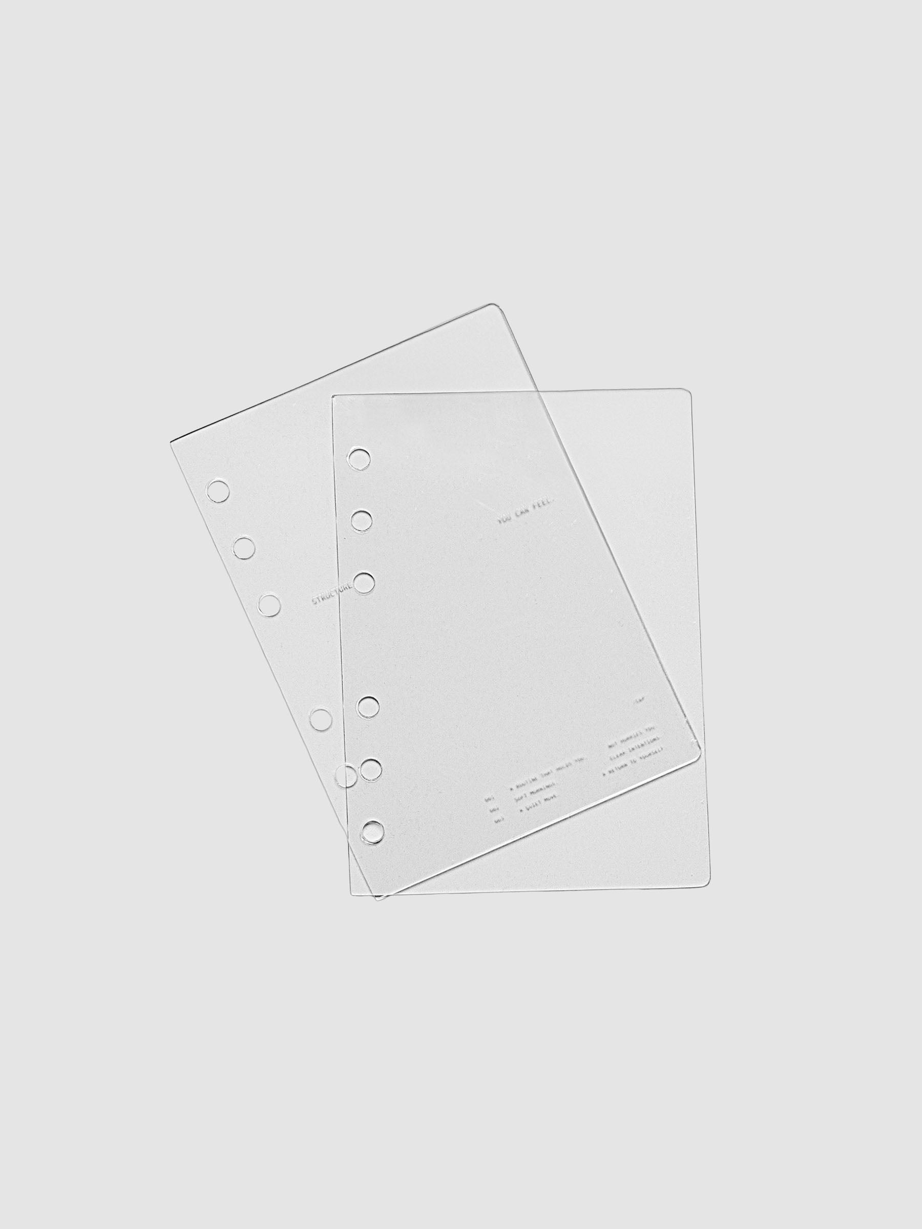 A6 sized crystal clear plastic planner cover set with text printed on the cover on the theme of structure and routines.