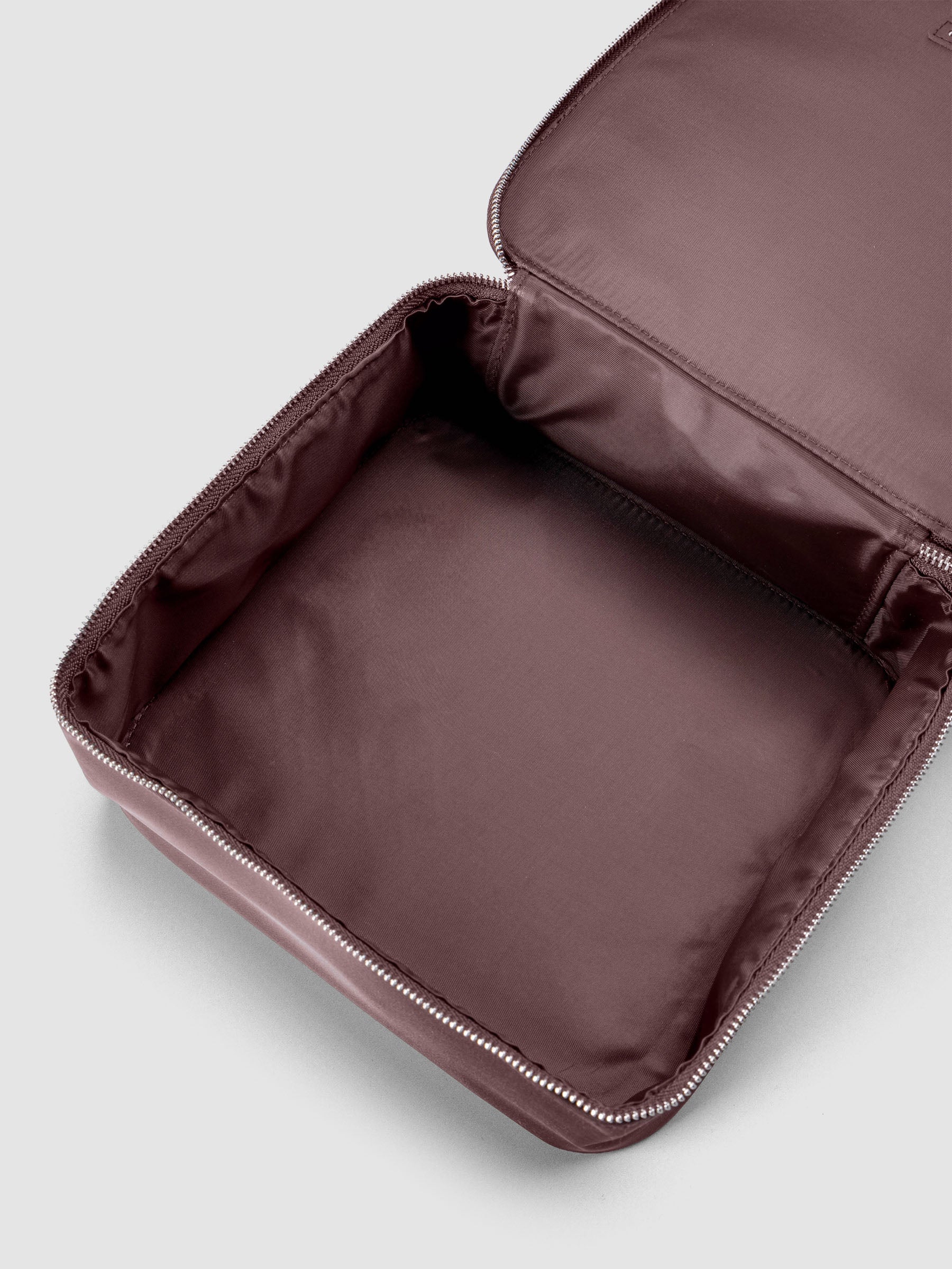 Medium packing cube shown unzipped and open in the color walnut against a neutral background; shown at an angle.