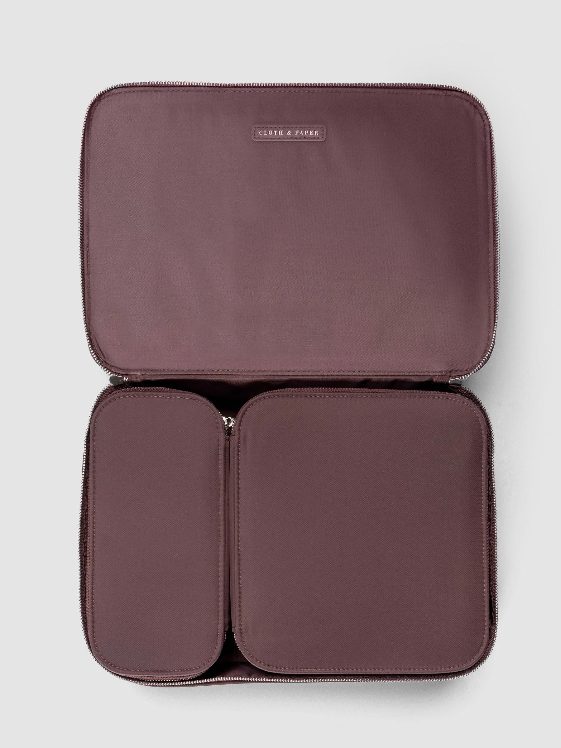 Small and medium packing cubes nested side by side inside the large packing cube all in the color walnut.