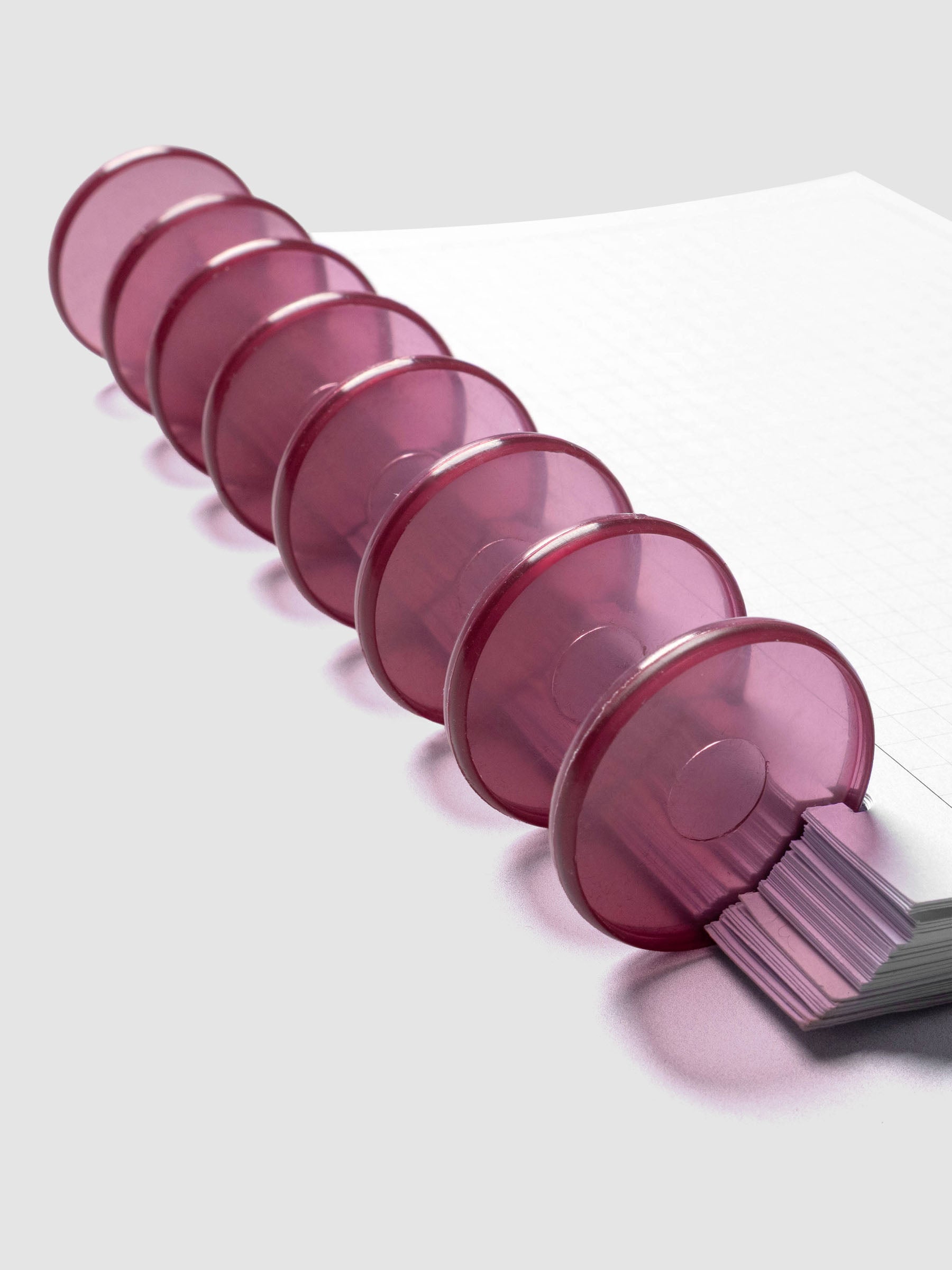 Planner Inserts in size Half Letter fitted onto Transparent Planner Discs | Bordeaux in size 1.5 in shown at an angle.