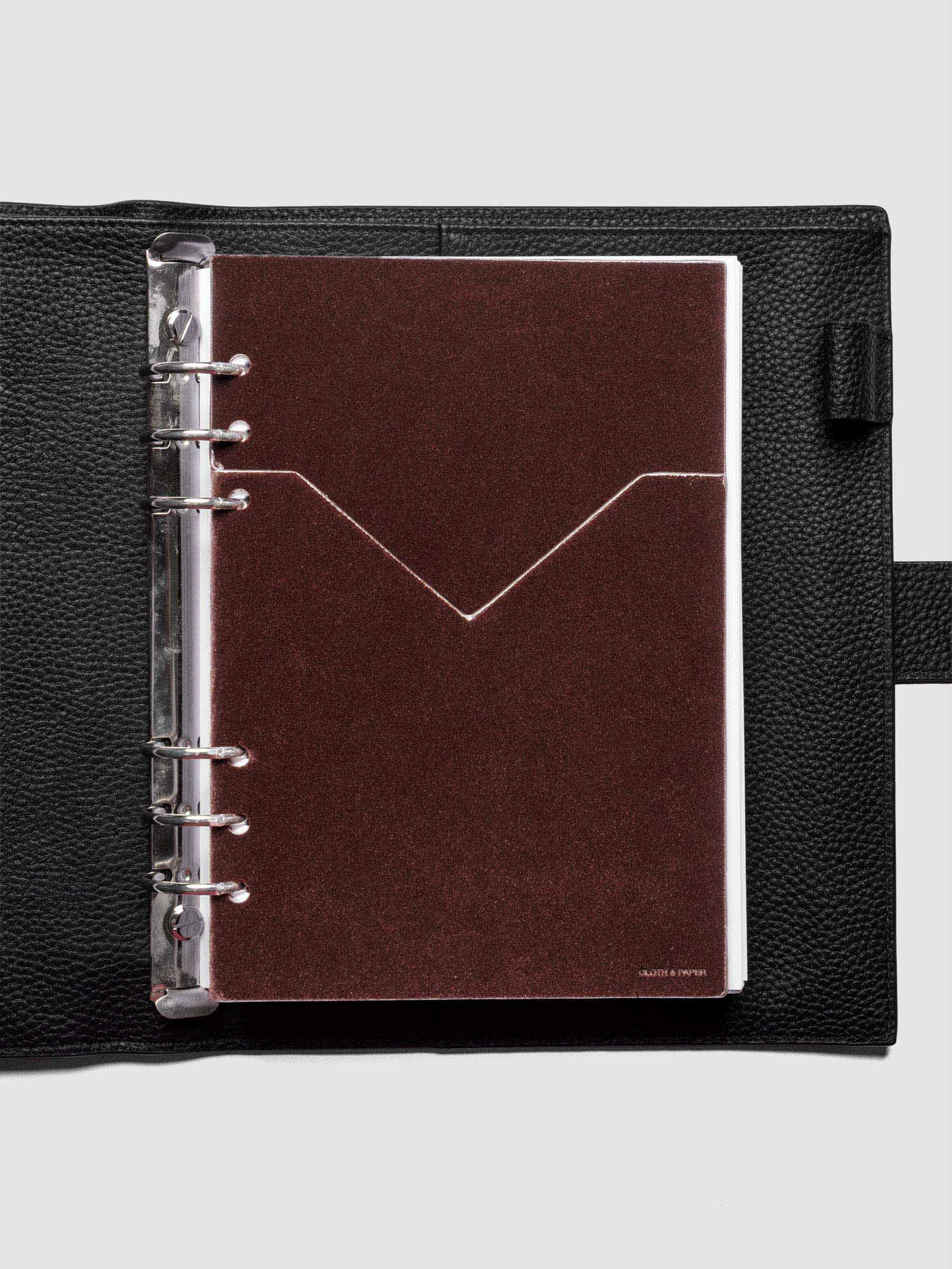 Velvet Pocket Folder in Bordeaux pre-punched for A5 planners shown in a black leather agenda.