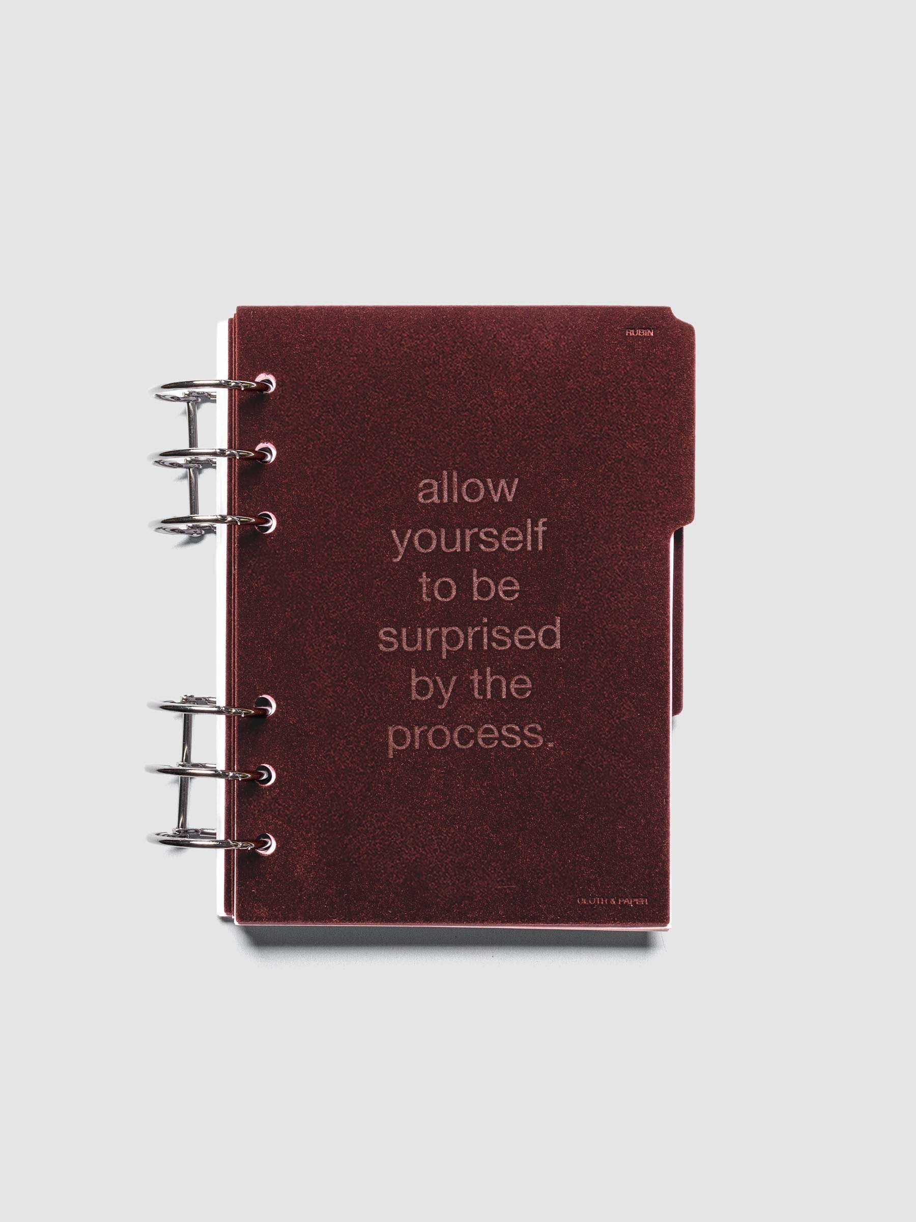 First velvet side tab planners dividers in the color Bordeaux with text deboss design reading "allow yourself to be surprised by the process" in size A6 shown ringbound.
