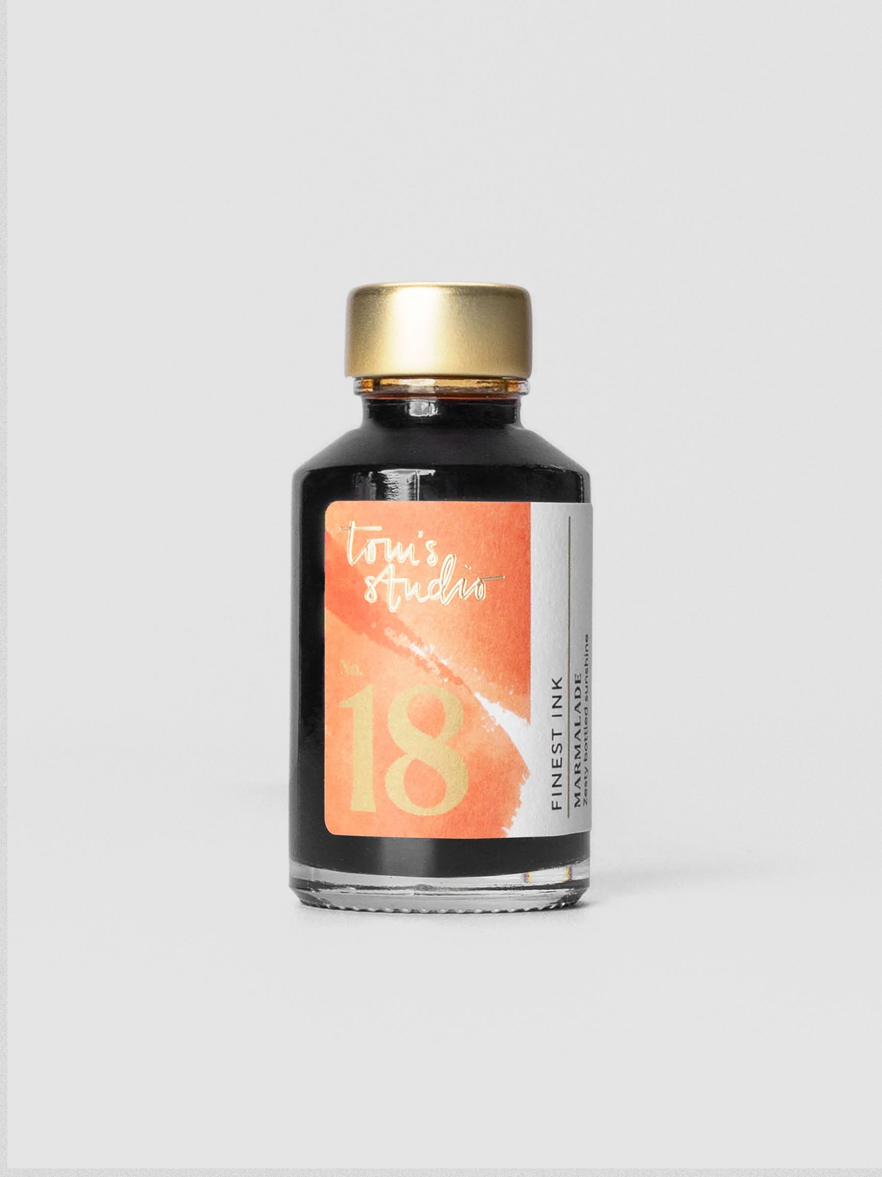 Tom’s Studio Fountain Pen Ink in Marmalade orange tone, shown in glass bottle.