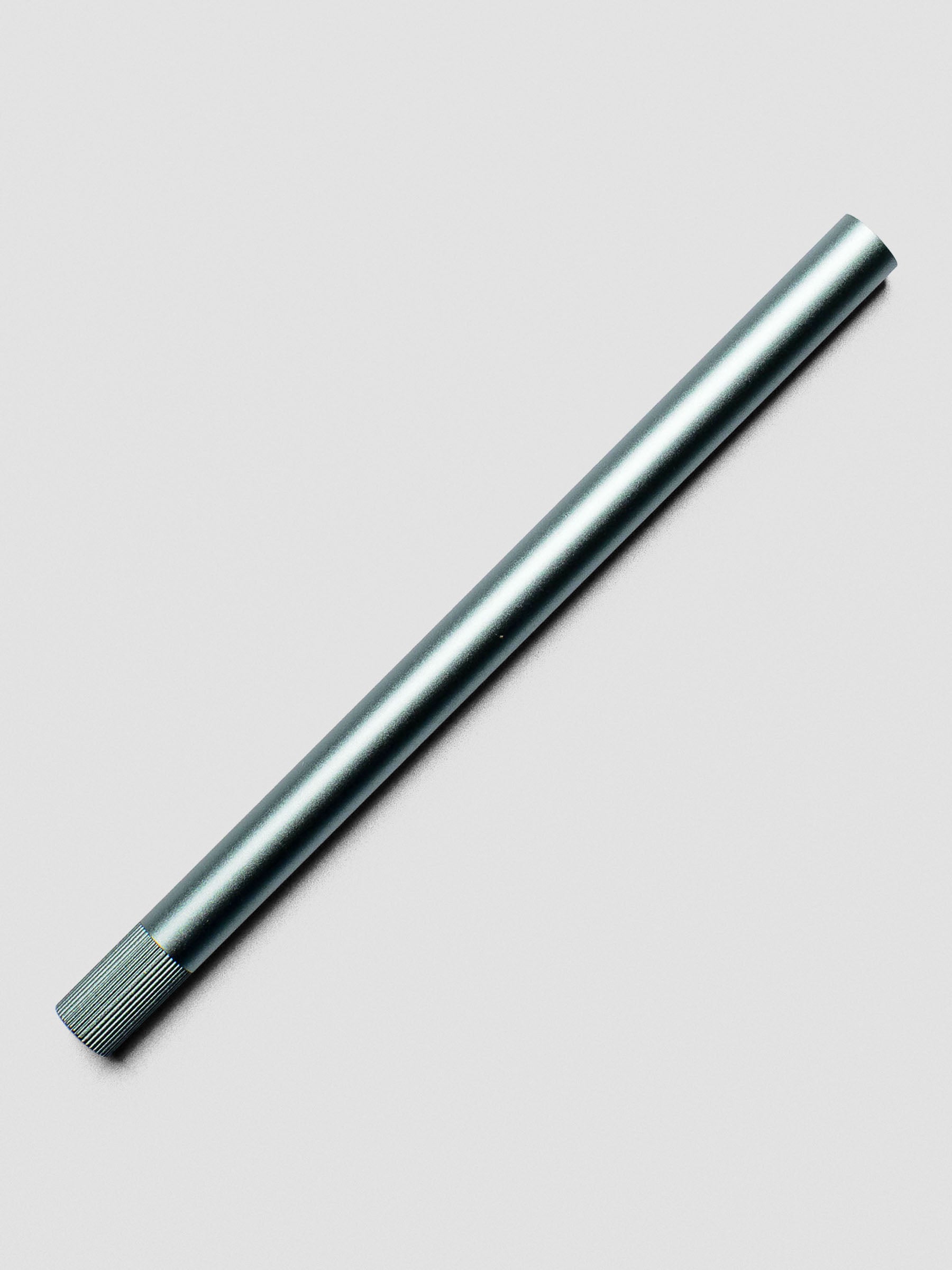 Sage green Lumos Pro Pen resting diagonally, capped.