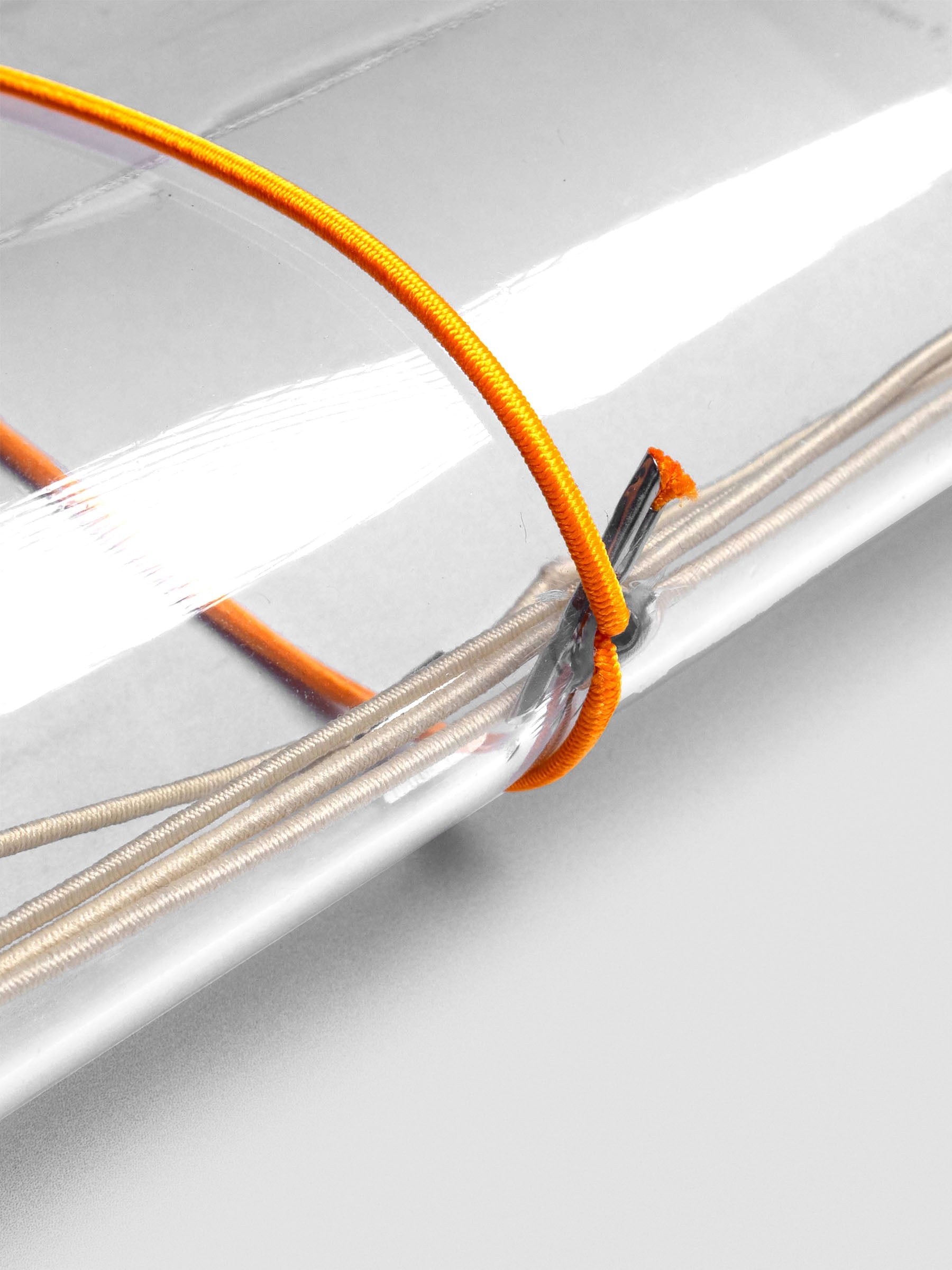 Orange elastic exterior band looped through clear vinyl travel cover spine.