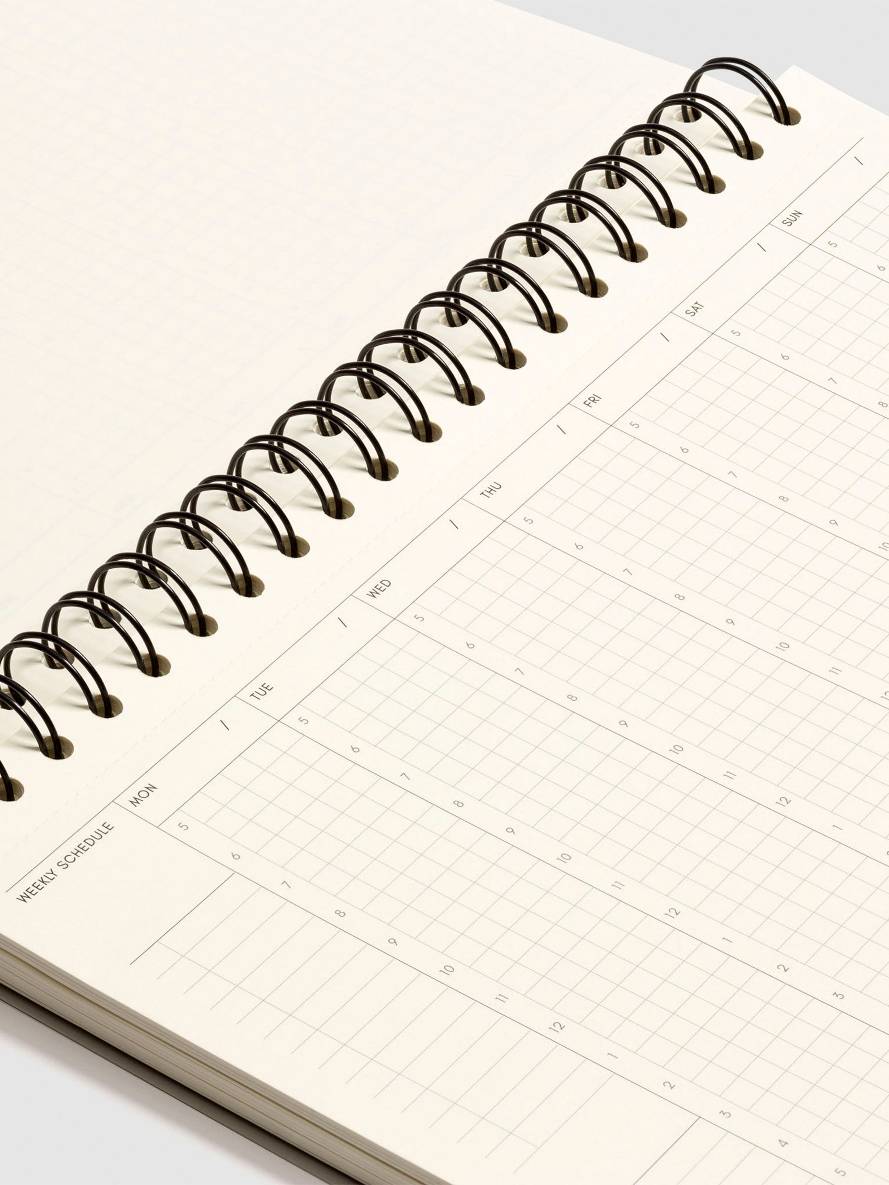 Close up of the spiral binding of the notebook and weekly schedule page.