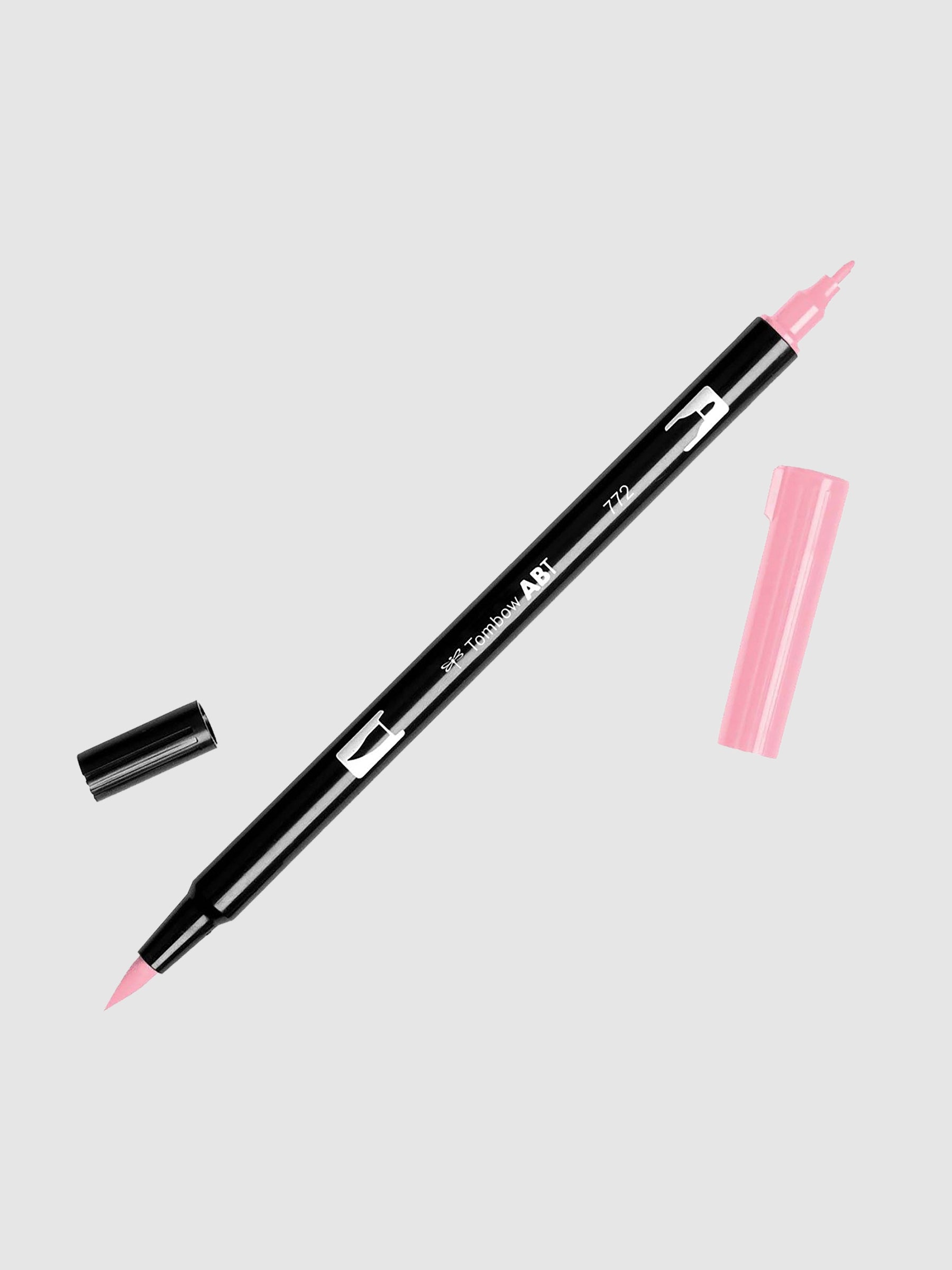 Tombow Dual Brush Art Marker, Dusty Rose, Cloth & Paper. Art marker turned slightly to the right on a neutral background. It is uncapped on both ends showing the brush tip and fine tip.