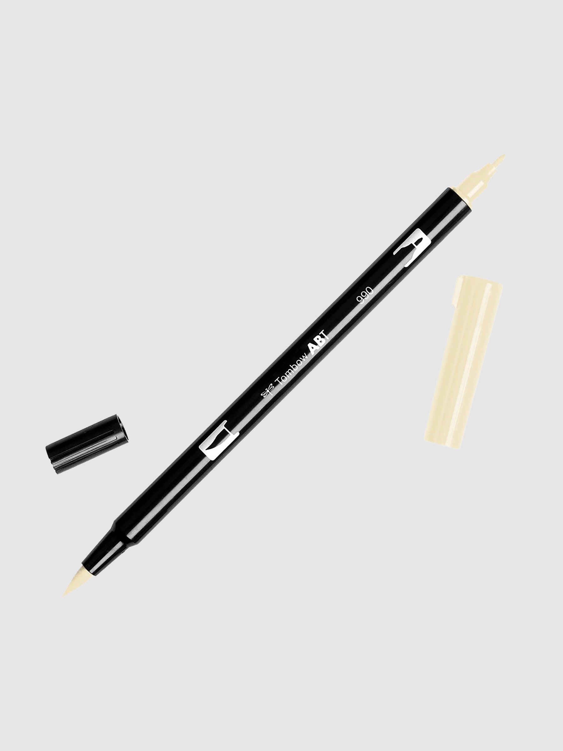 Tombow Dual Brush Art Marker, Light Sand, Cloth & Paper. Art marker turned slightly to the right on a neutral background. It is uncapped on both ends showing the brush tip and fine tip.