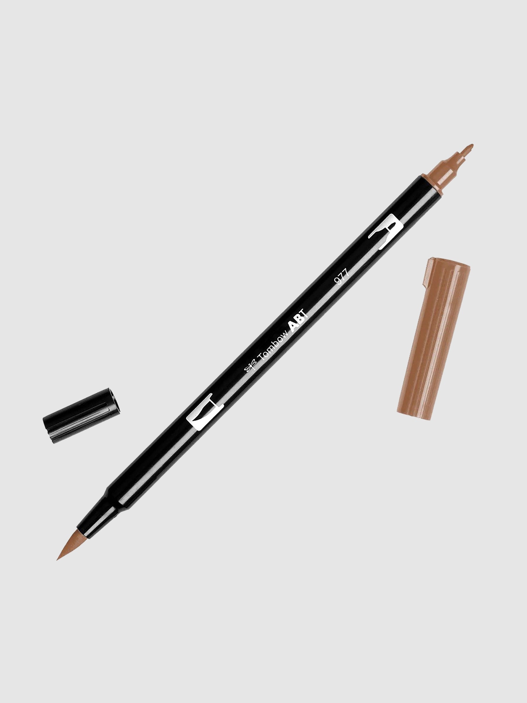 Tombow Dual Brush Art Marker, Saddle Brown, Cloth & Paper. Art marker turned slightly to the right on a neutral background. It is uncapped on both ends showing the brush tip and fine tip.