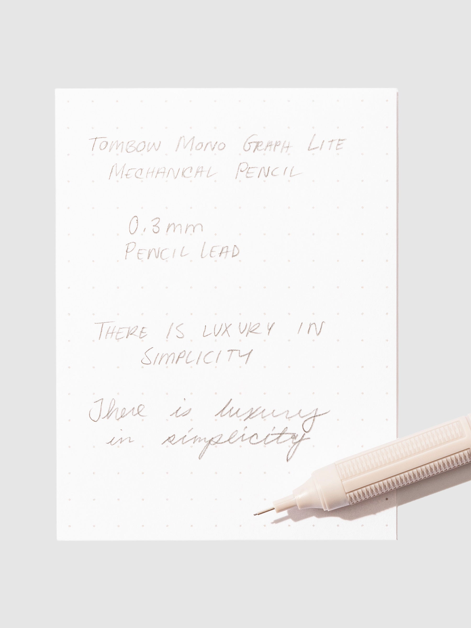 Writing sample with pencil displayed on a neutral background.