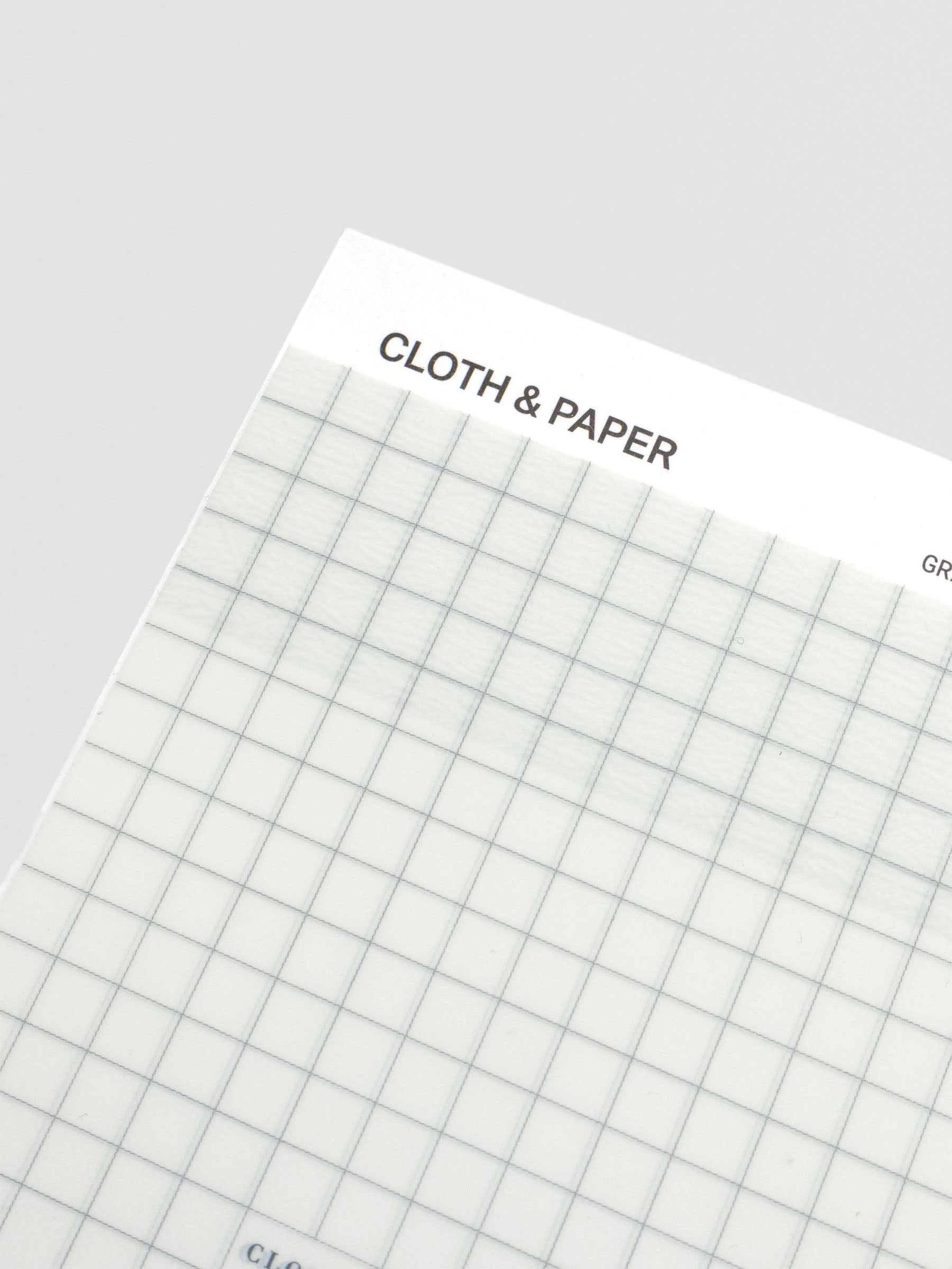 Close-up angled view of the transparent sticky note pad, highlighting the grid lines.