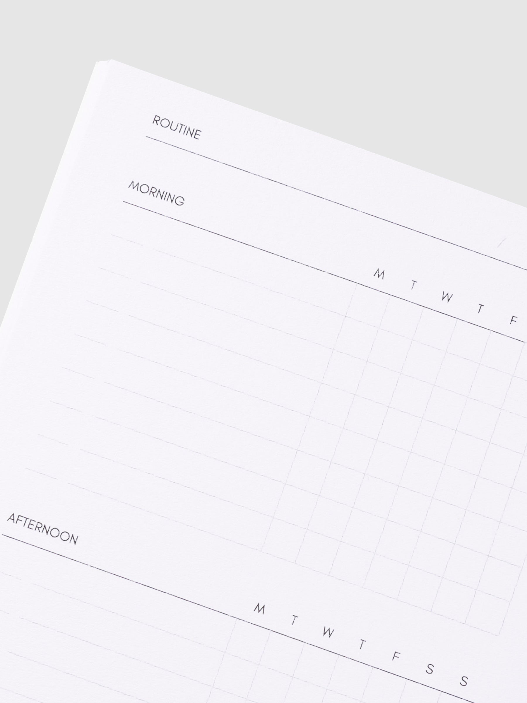 Close up image of the top left corner of the routine builder notebook page. The page is turned on a left angle and is displayed on a light gray background