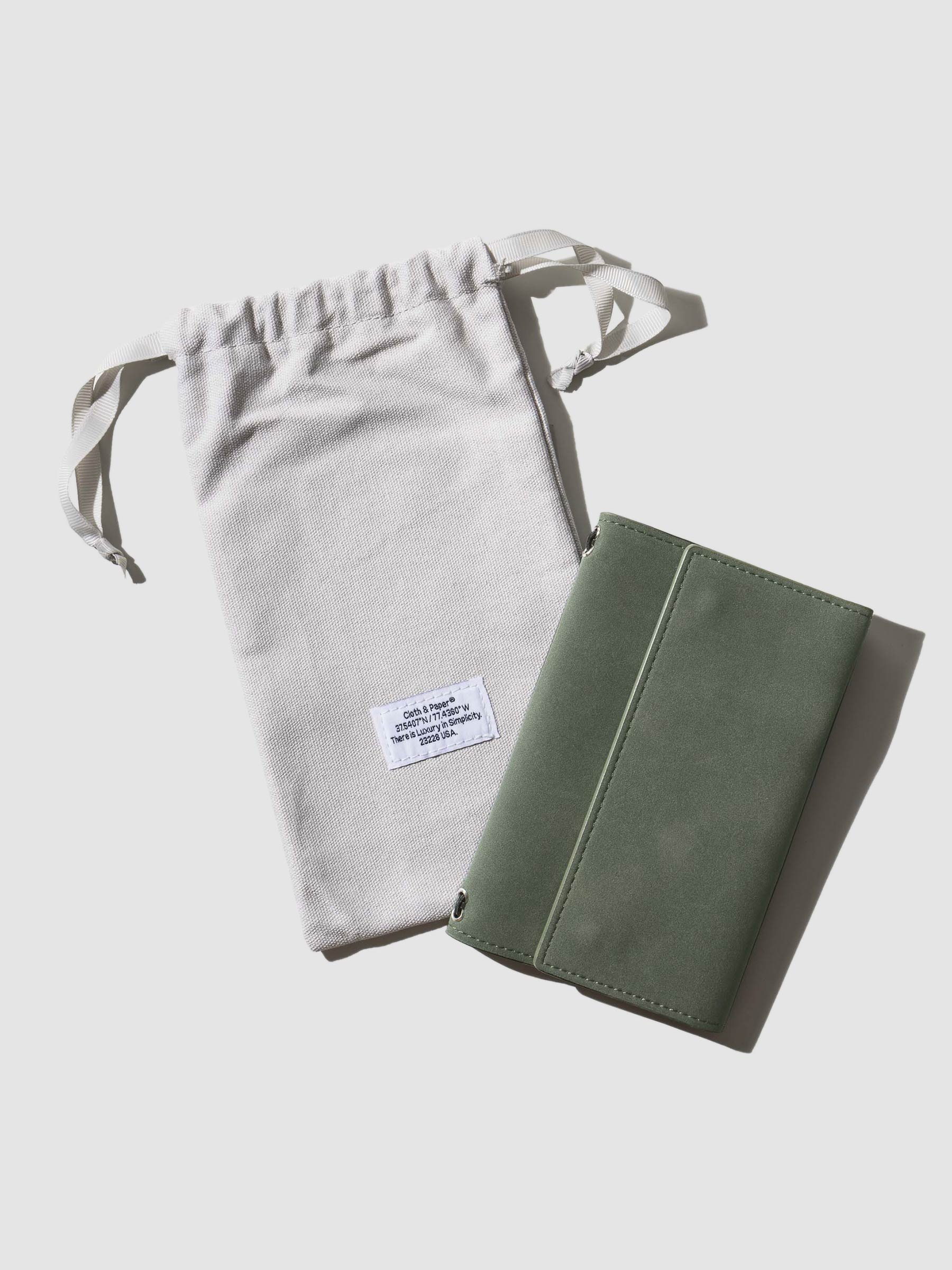 Travel Refillable Notebook Cover, Cypress, Cloth and Paper. Notebook cover shown with dust bag on a neutral background.