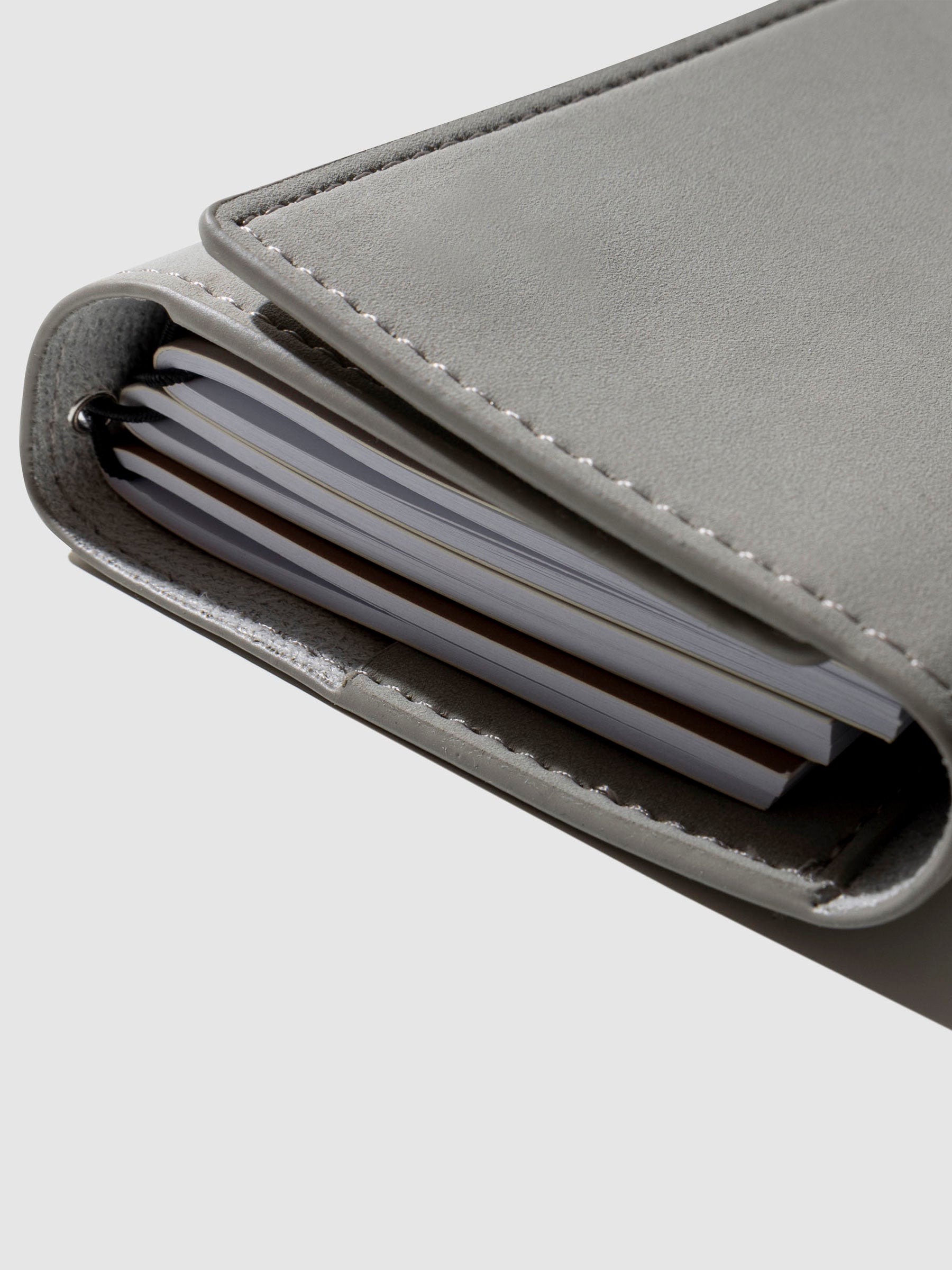 Closeup of cover shown with four notebooks inside it.