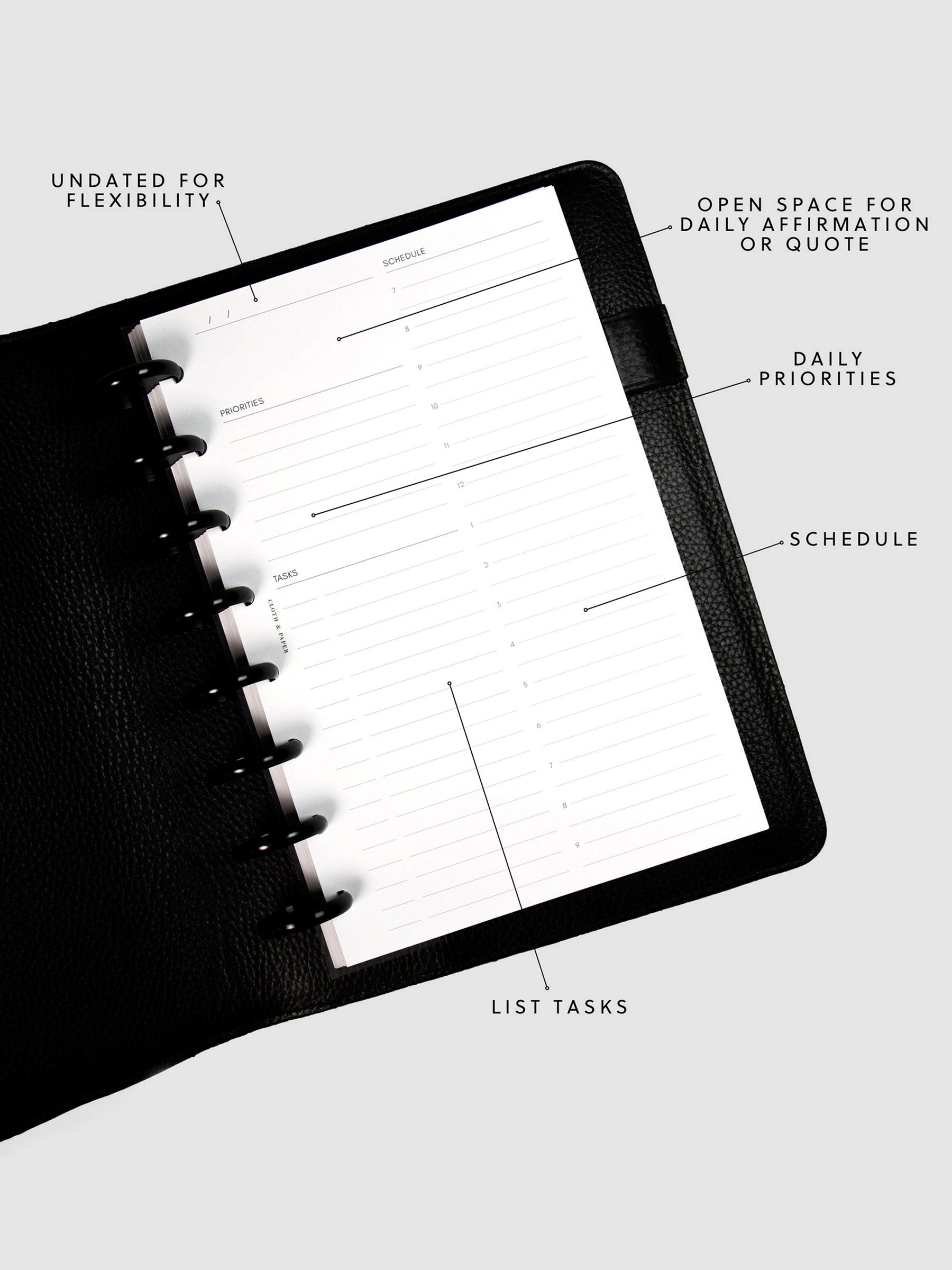 Undated Daily Planner Inserts in a black discbound planner tilted slightly to the left. Annotations for the sections include: Undated for Flexibility, Open Space for Daily Affirmation or Quote, Daily Priorities, Schedule and List Tasks