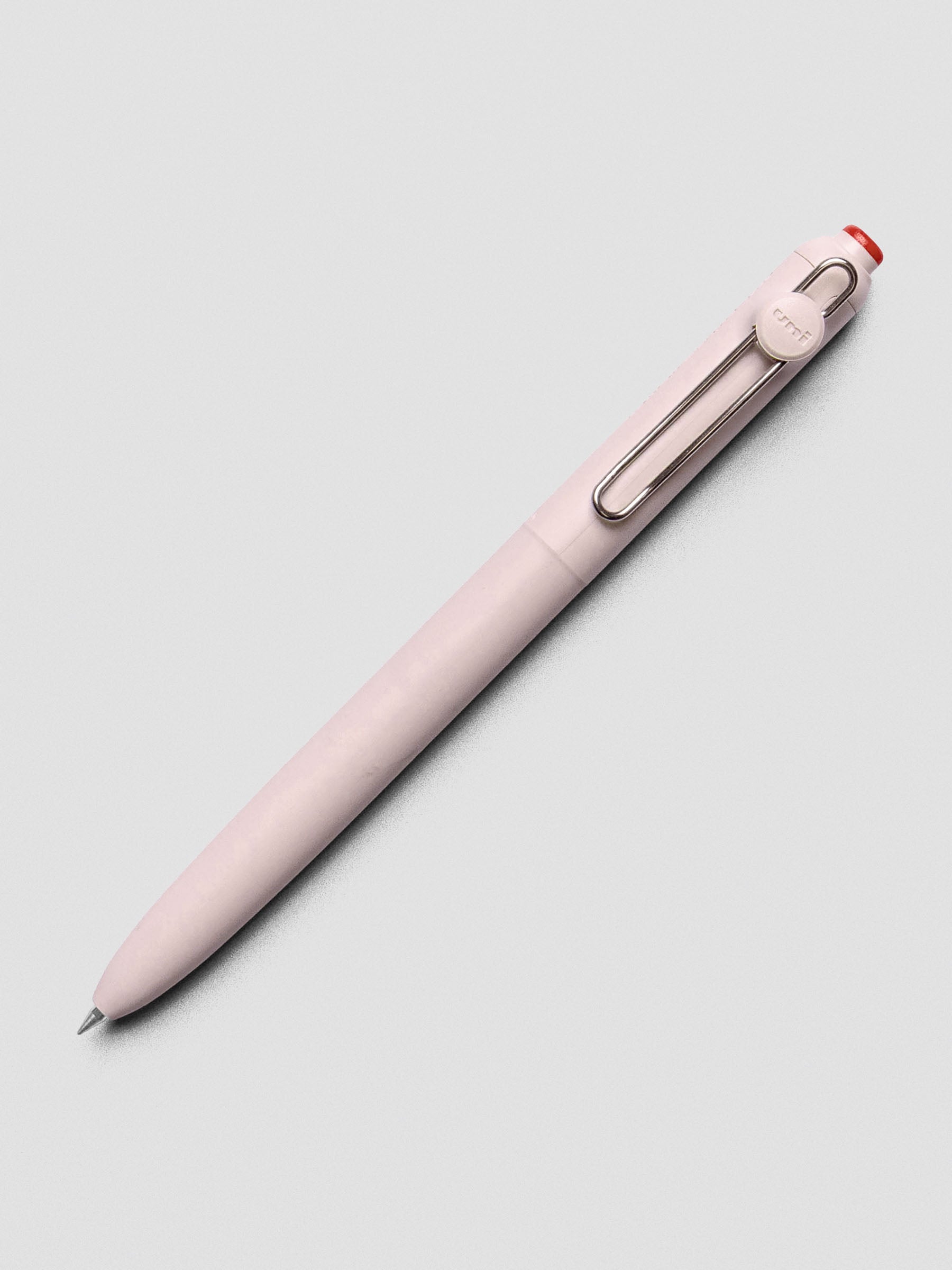 Pink/red pen shown at an angle with a silver clip.