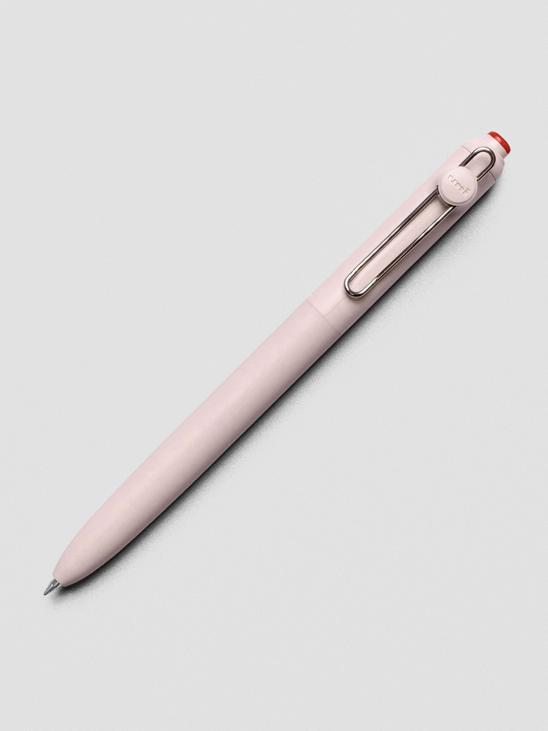 Pink/red pen shown at an angle with a silver clip.