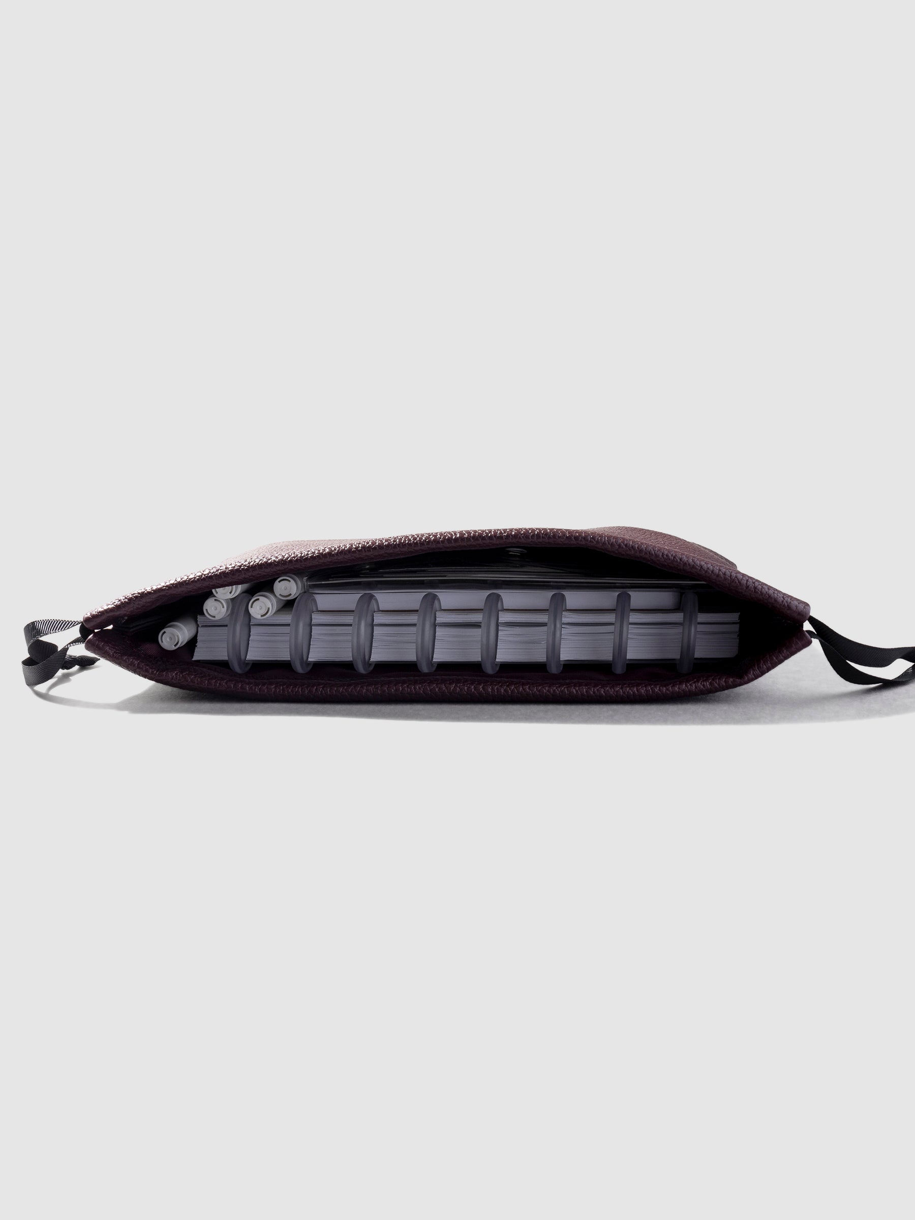 Side view of vegan leather dust bag in Bordeaux showing interior space with contents partially visible.