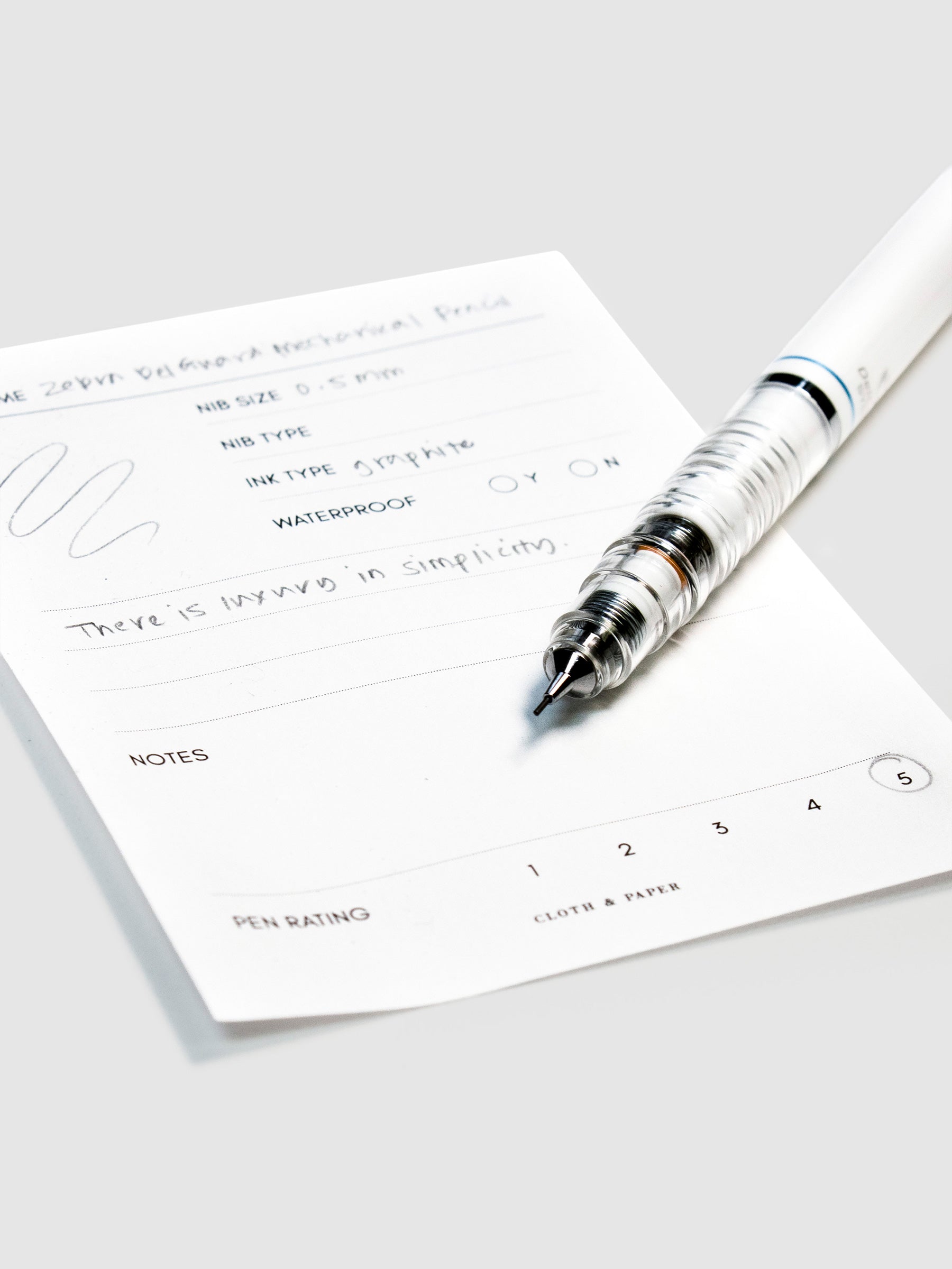 Close up on pencil nib with lead resting on its pen test sheet.