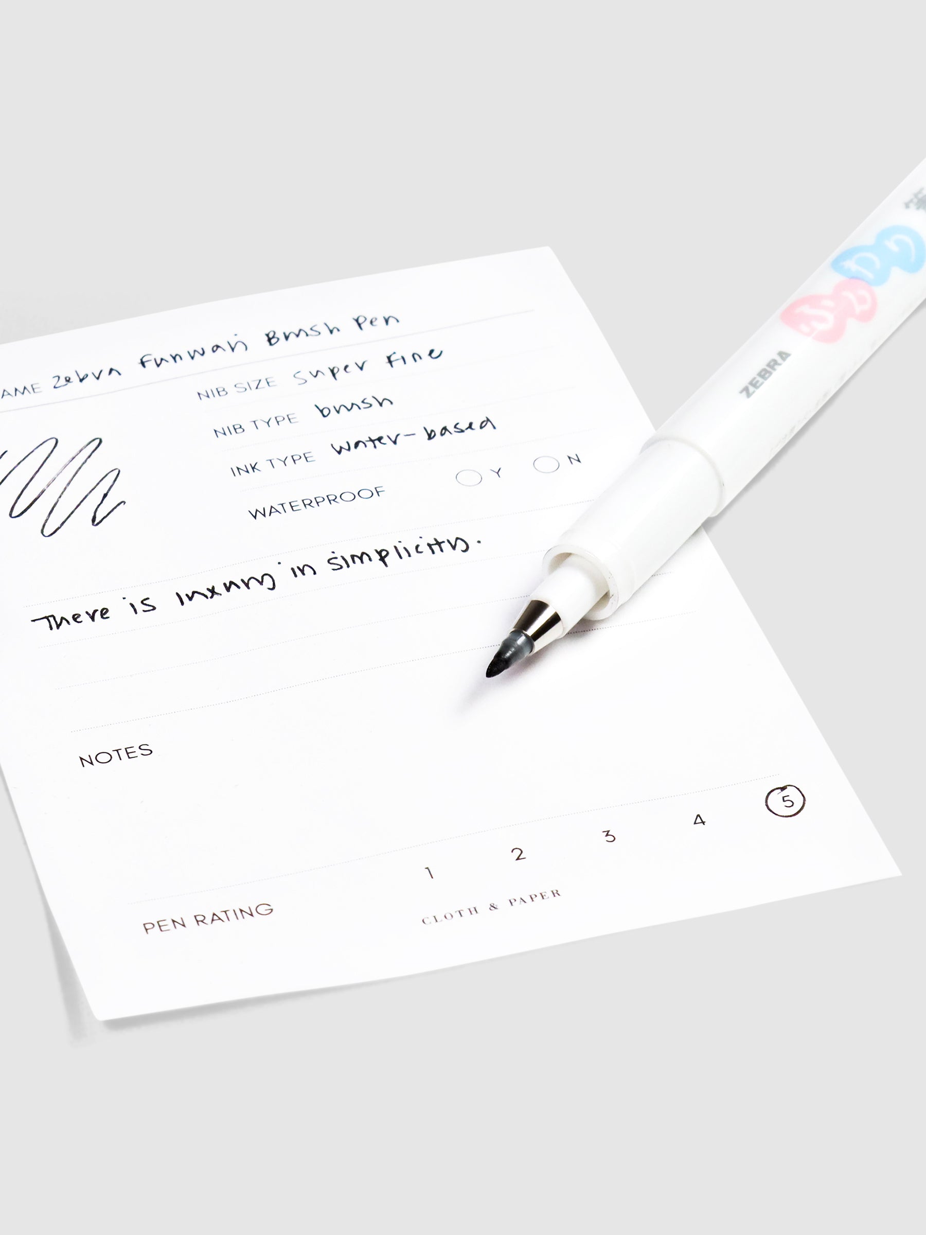 Close up on pen nib resting on pen test sheet.