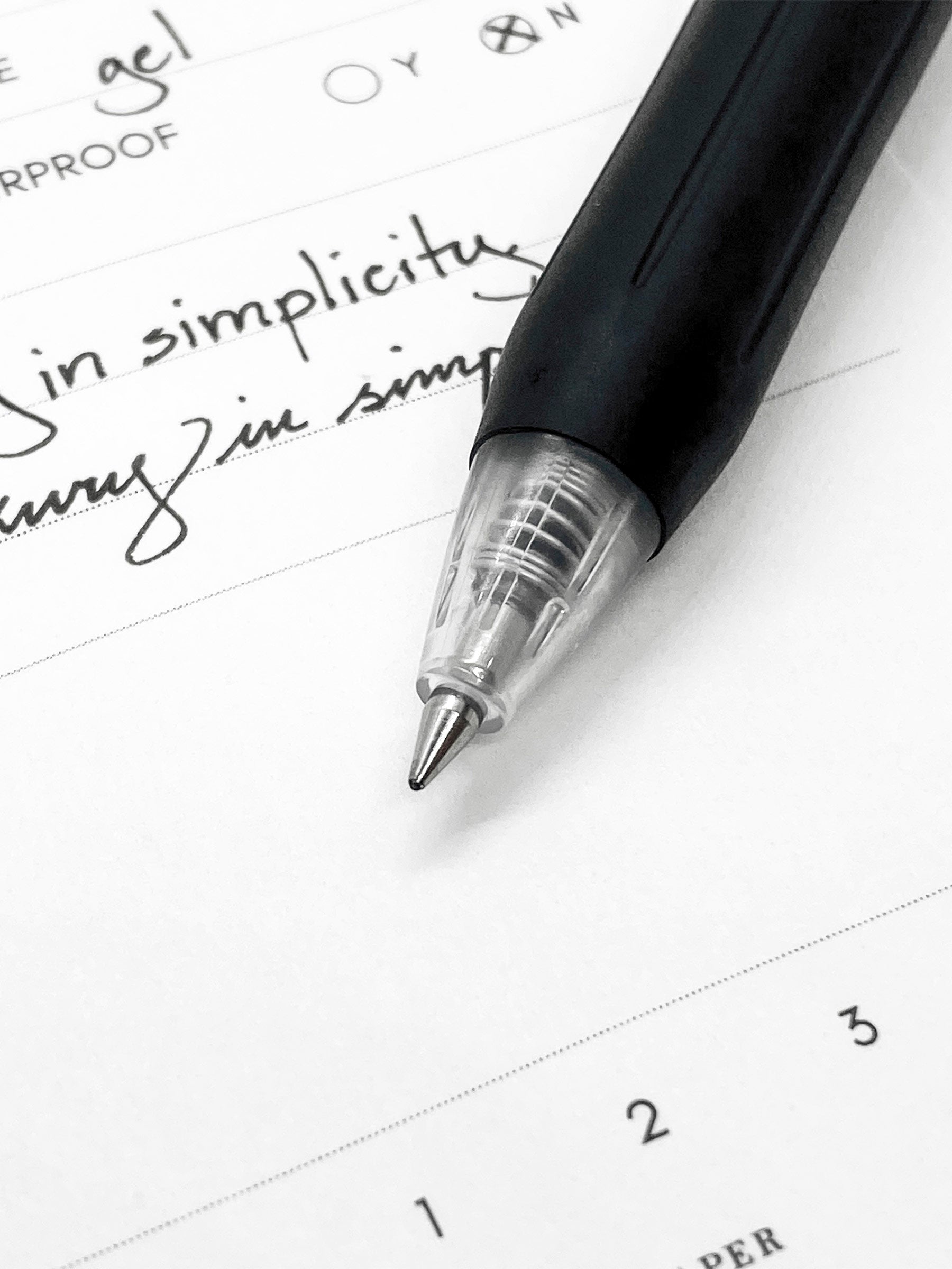 Zebra Sarasa Clip, 0.5 mm, Black, Cloth and Paper. Close up on pen nib and writing sample.