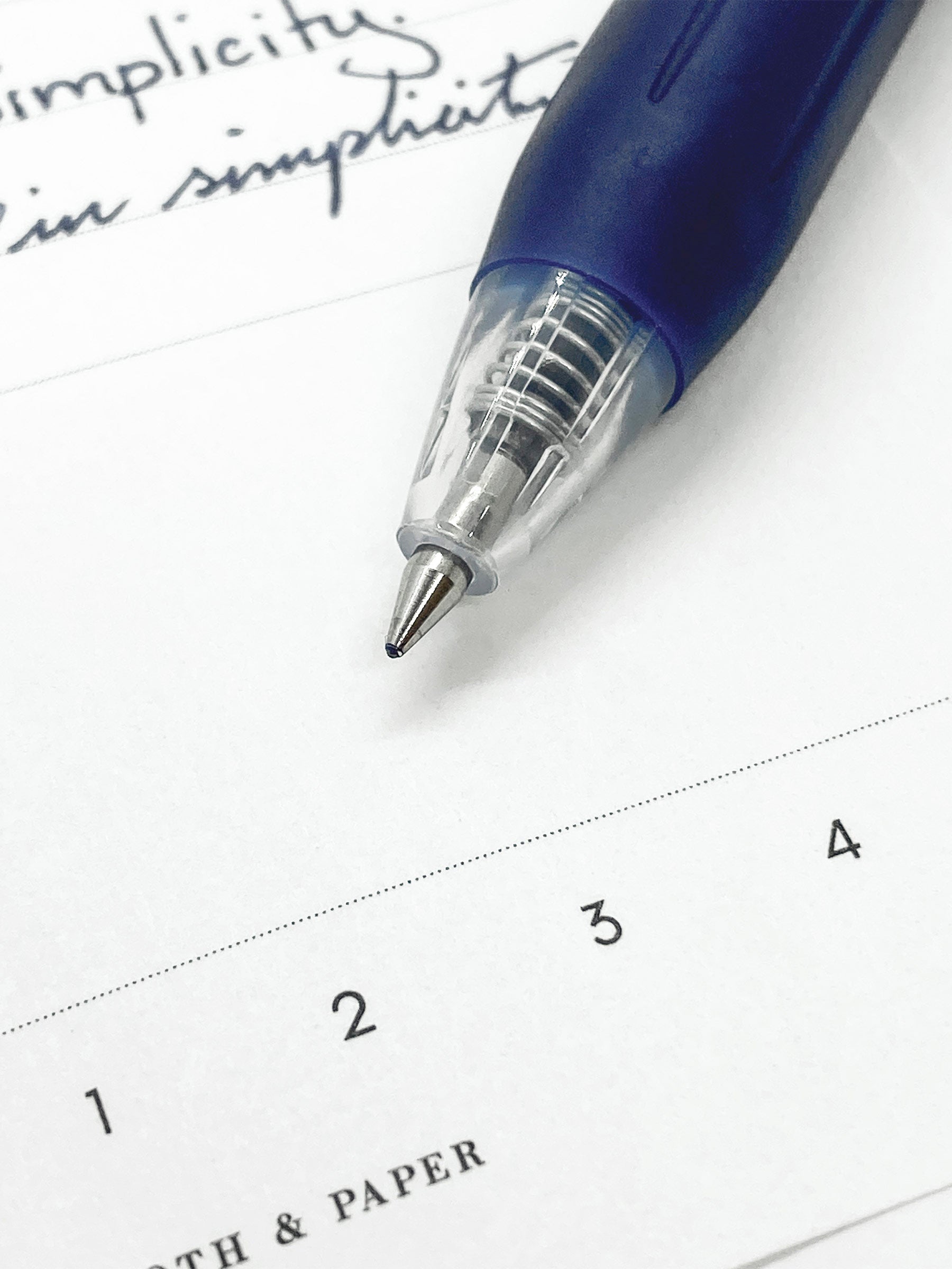 Zebra Sarasa Clip, 0.5 mm, Blue Black, Cloth and Paper. Close up on pen nib and writing sample.