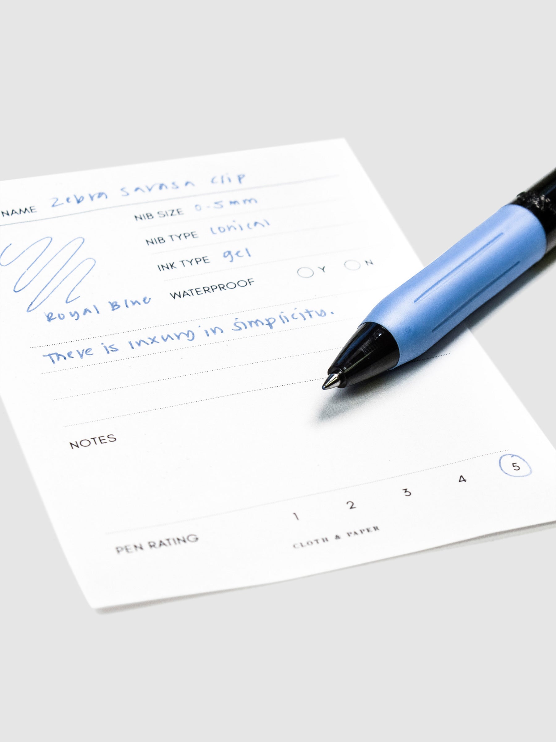 Close up on nib of pen resting on its pen test sheet.