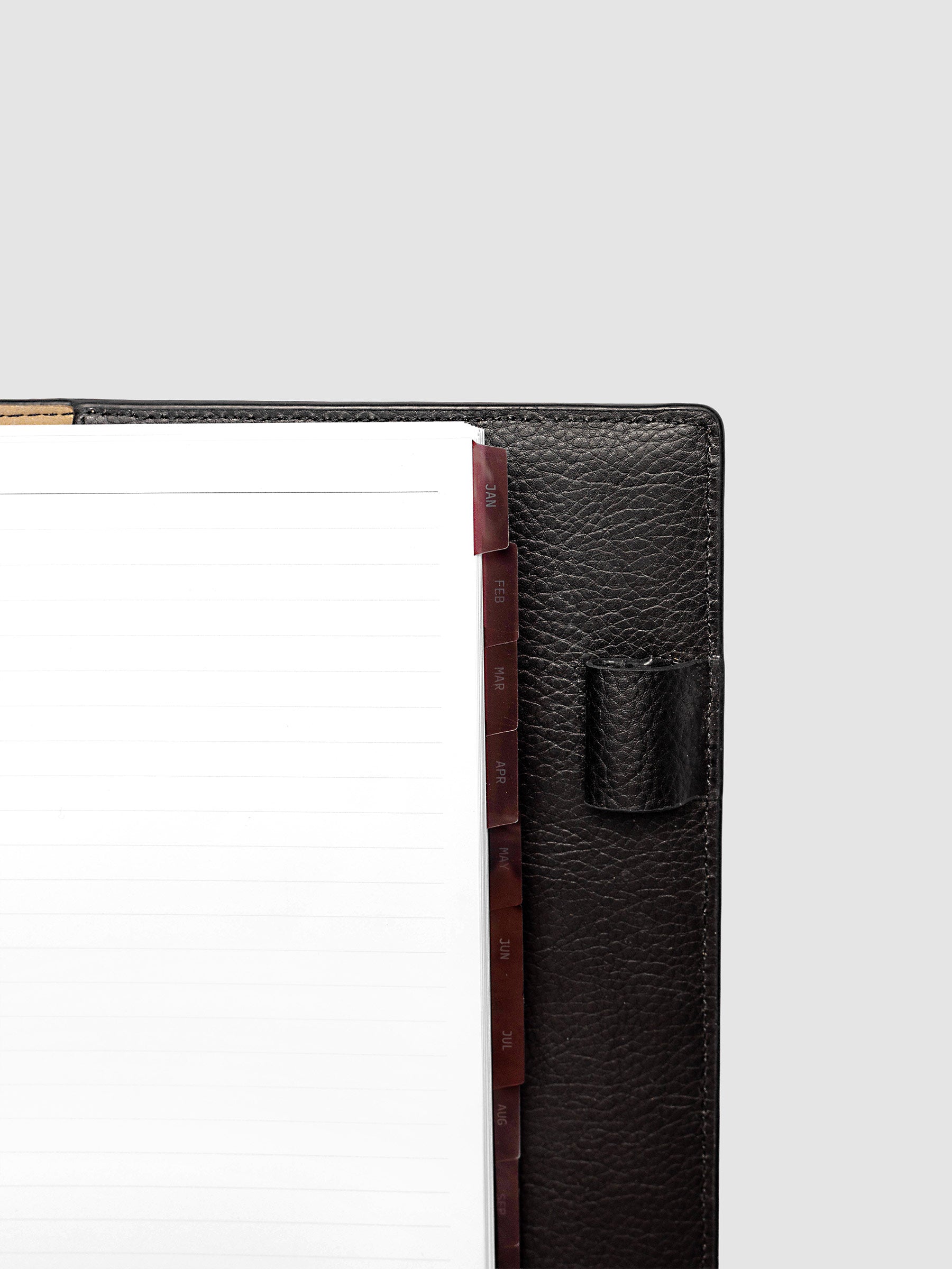 Top right corner close-up of deep red monthly divider in A5 6-Ring Punch planner showing tab label detail