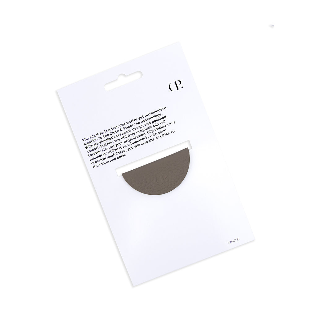 Contoured leather clip in its packaging tilted to the left on a white background.