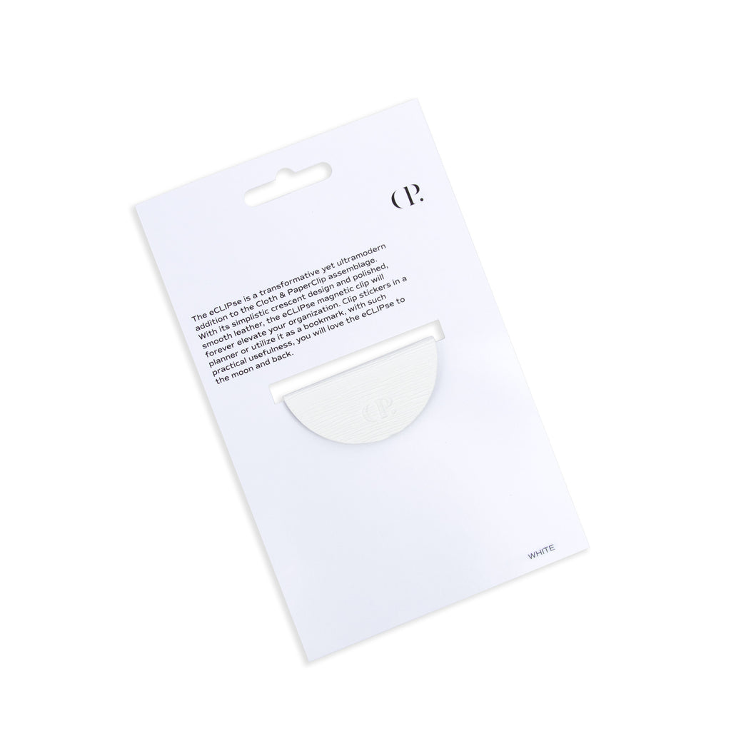 White contoured leather clip in its packaging tilted to the left on a white background.