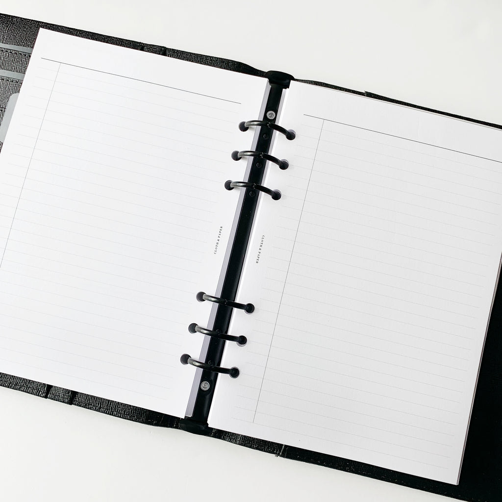 Two pages of inserts styled inside a black leather agenda with black rings.