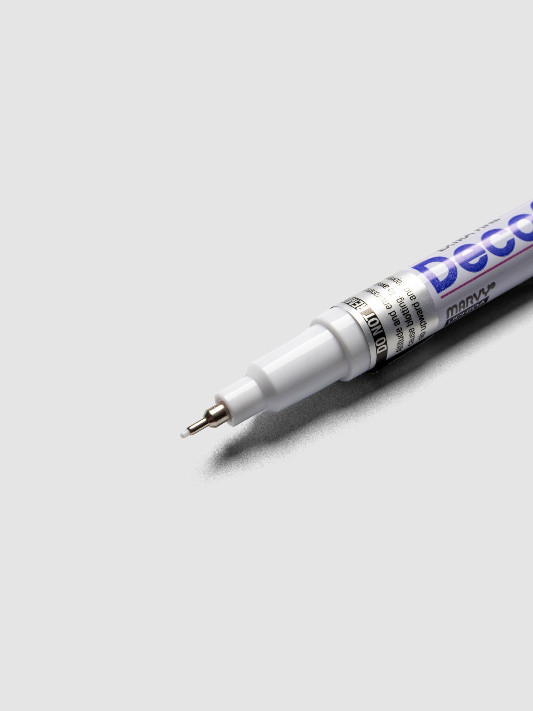 Close up of the White DecoColor paint marker in extra fine showing the nib