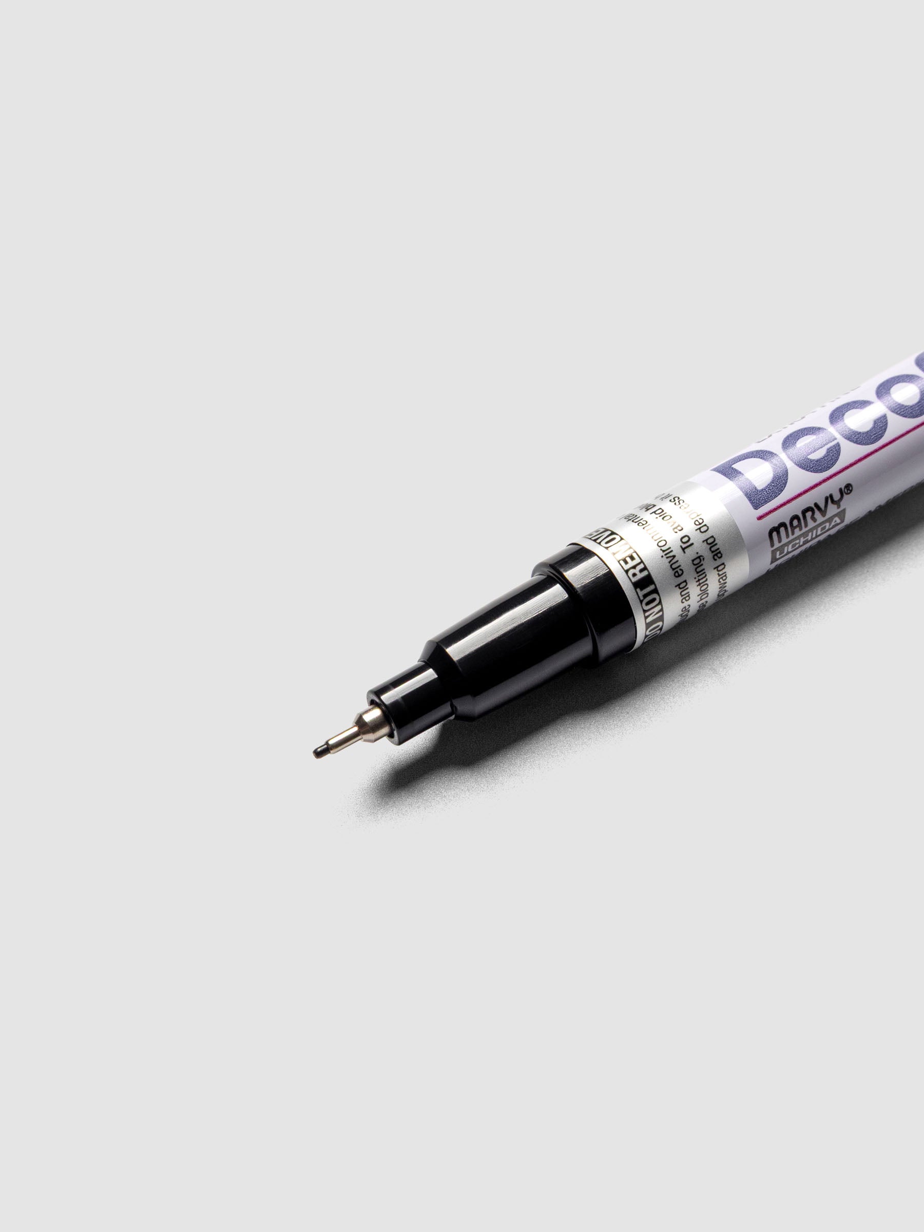Close up of the Black DecoColor paint marker in extra fine showing the nib